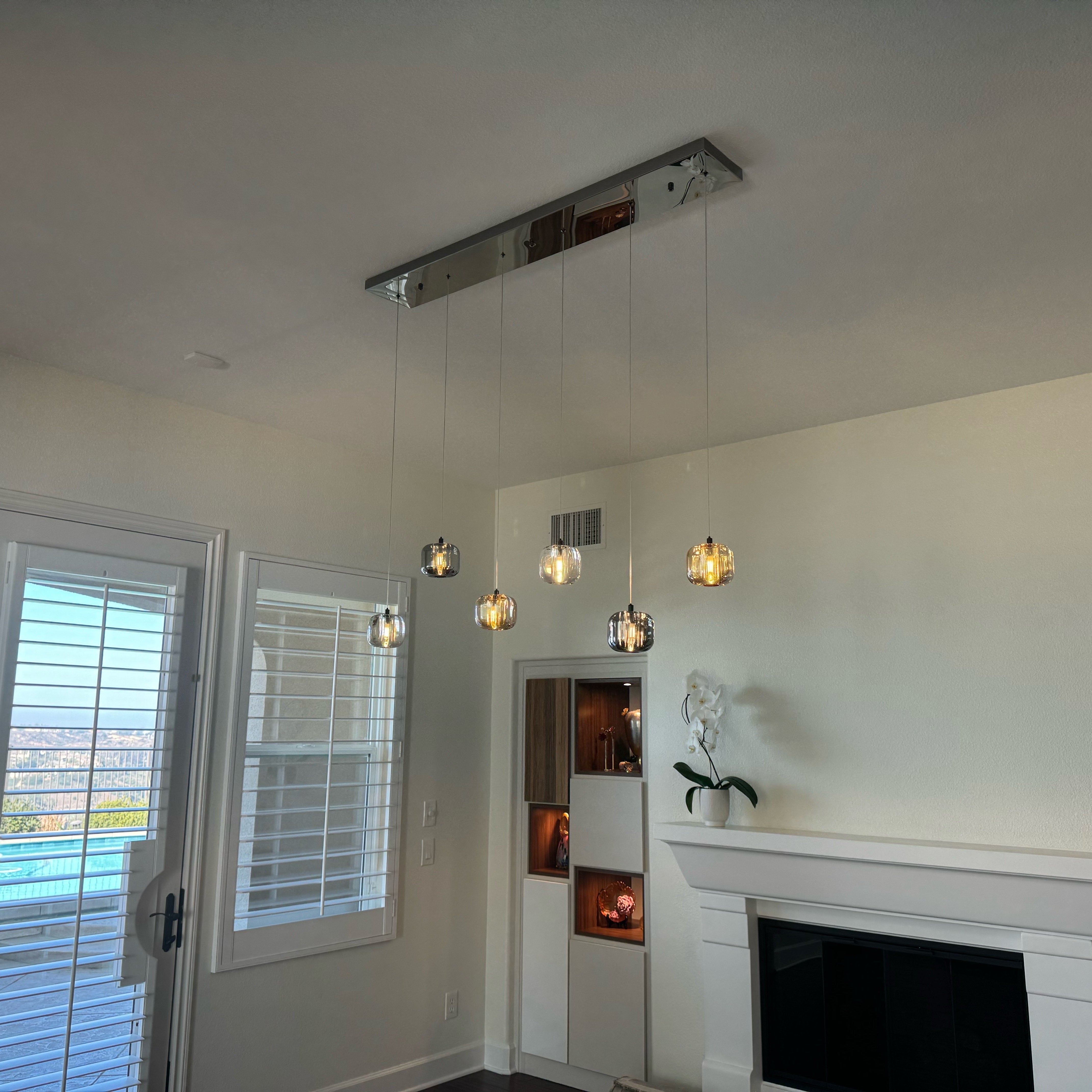 Luxury rectangular glass pendant chandelier above modern dining space by VORELLI®