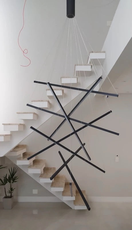 Luxury modern staircase interior featuring the Esher linear LED pendant chandelier by VORELLI®