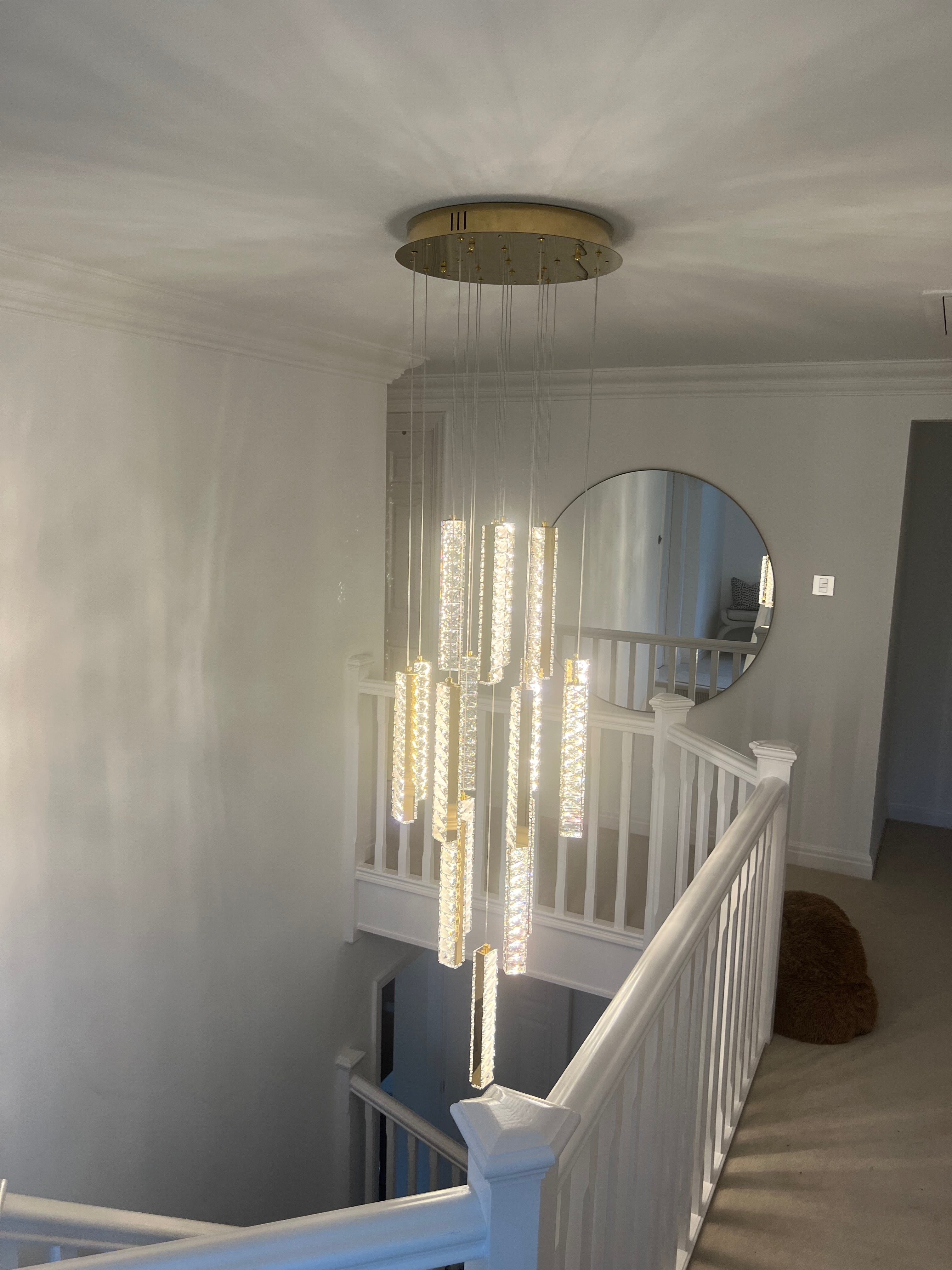 Crystal pendant staircase chandelier installed in a contemporary stairwell interior