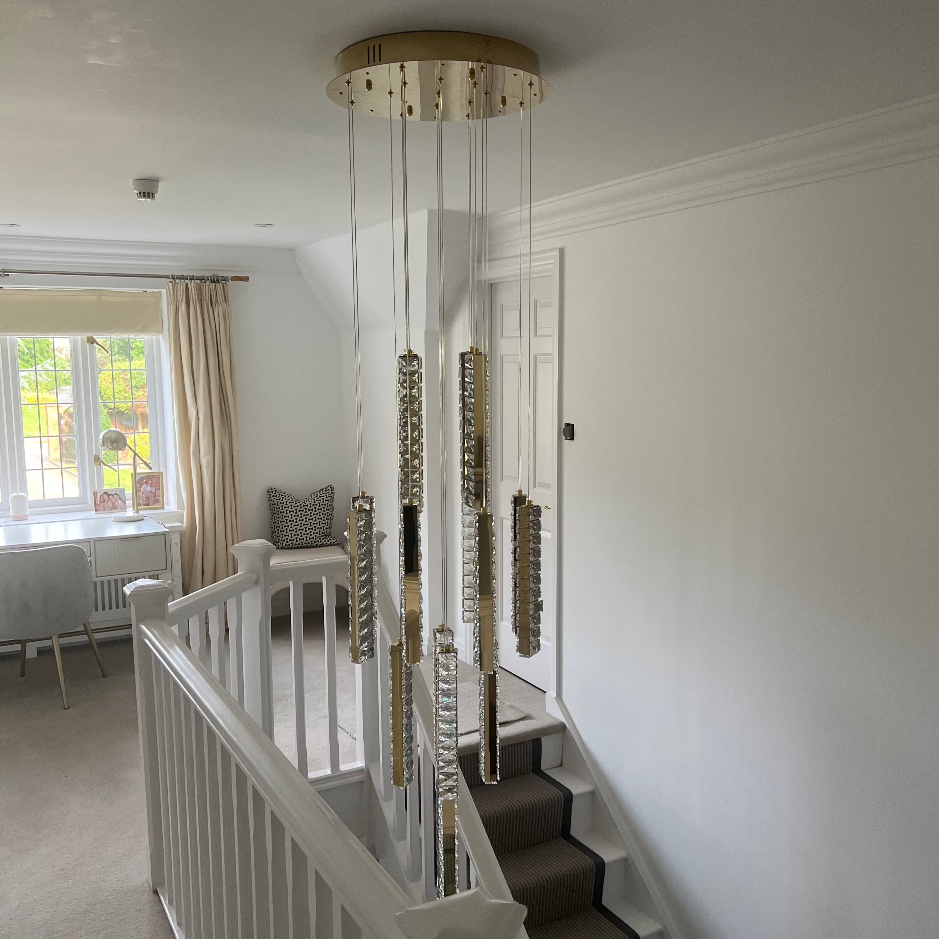 Fantasia pendant chandelier illuminating modern staircase landing