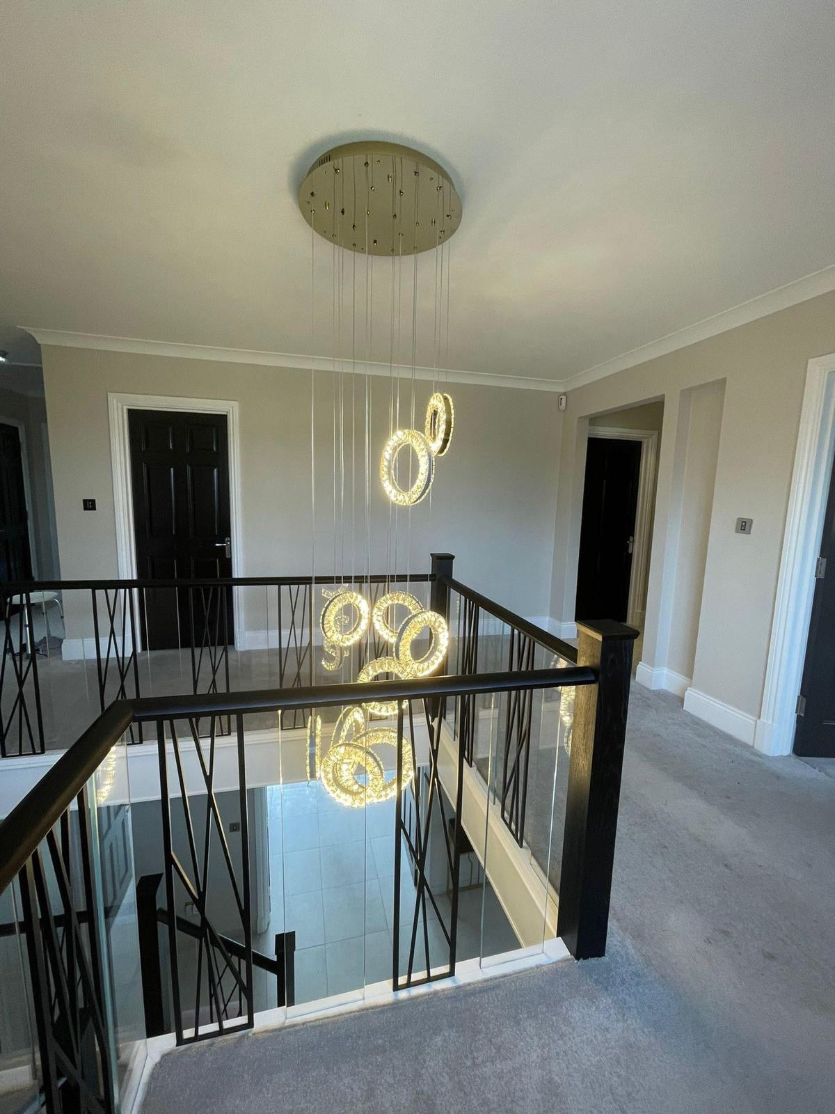 Contemporary Farnham ring chandelier creating statement lighting within a luxury staircase interior