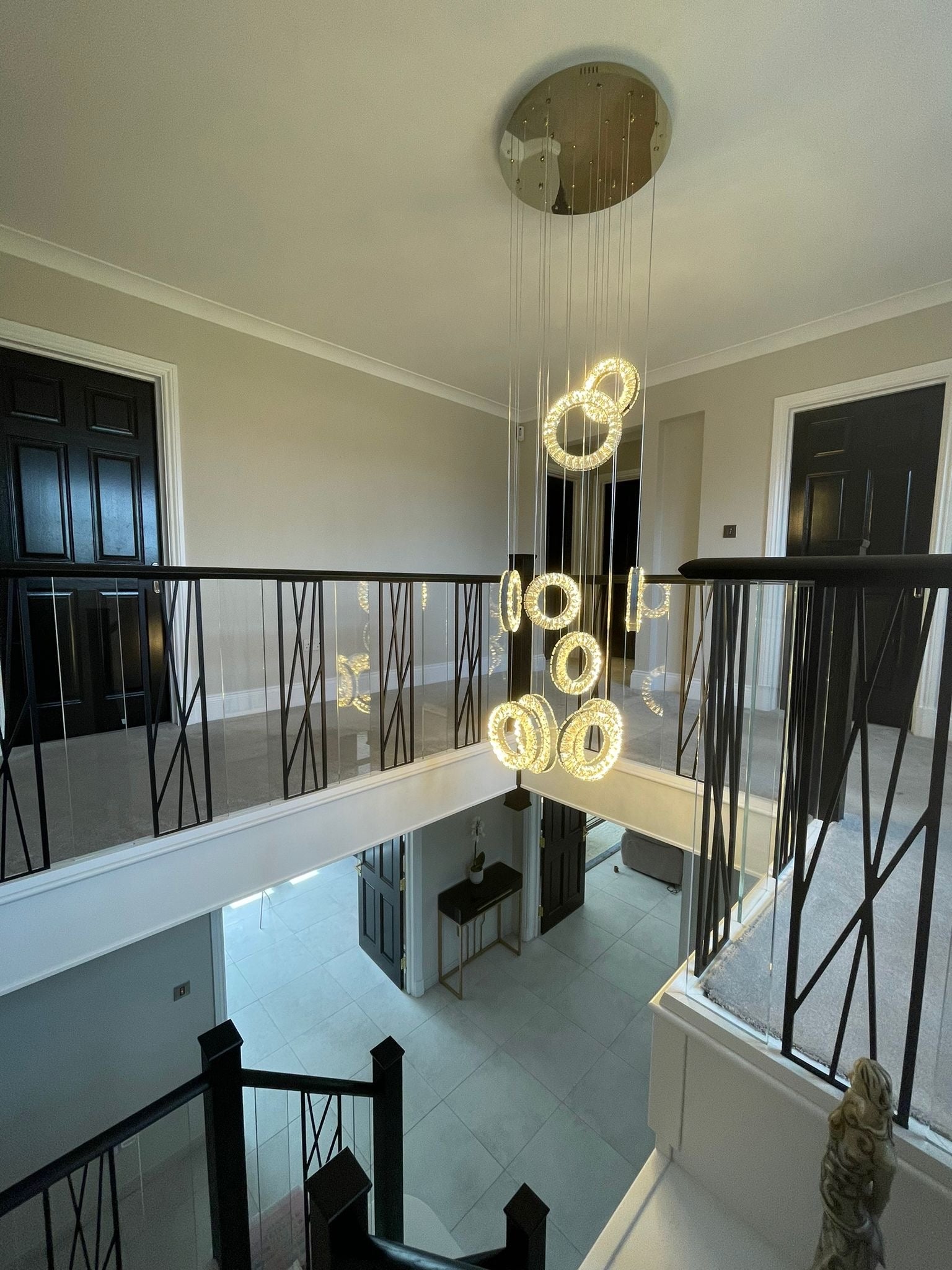 Luxury Farnham LED ring staircase chandelier suspended from a circular ceiling plate in a modern home.