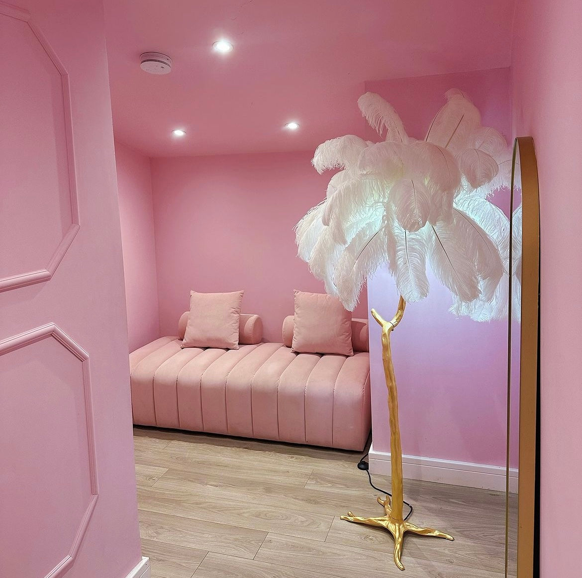 Luxury feather floor lamp with gold base in boutique interior