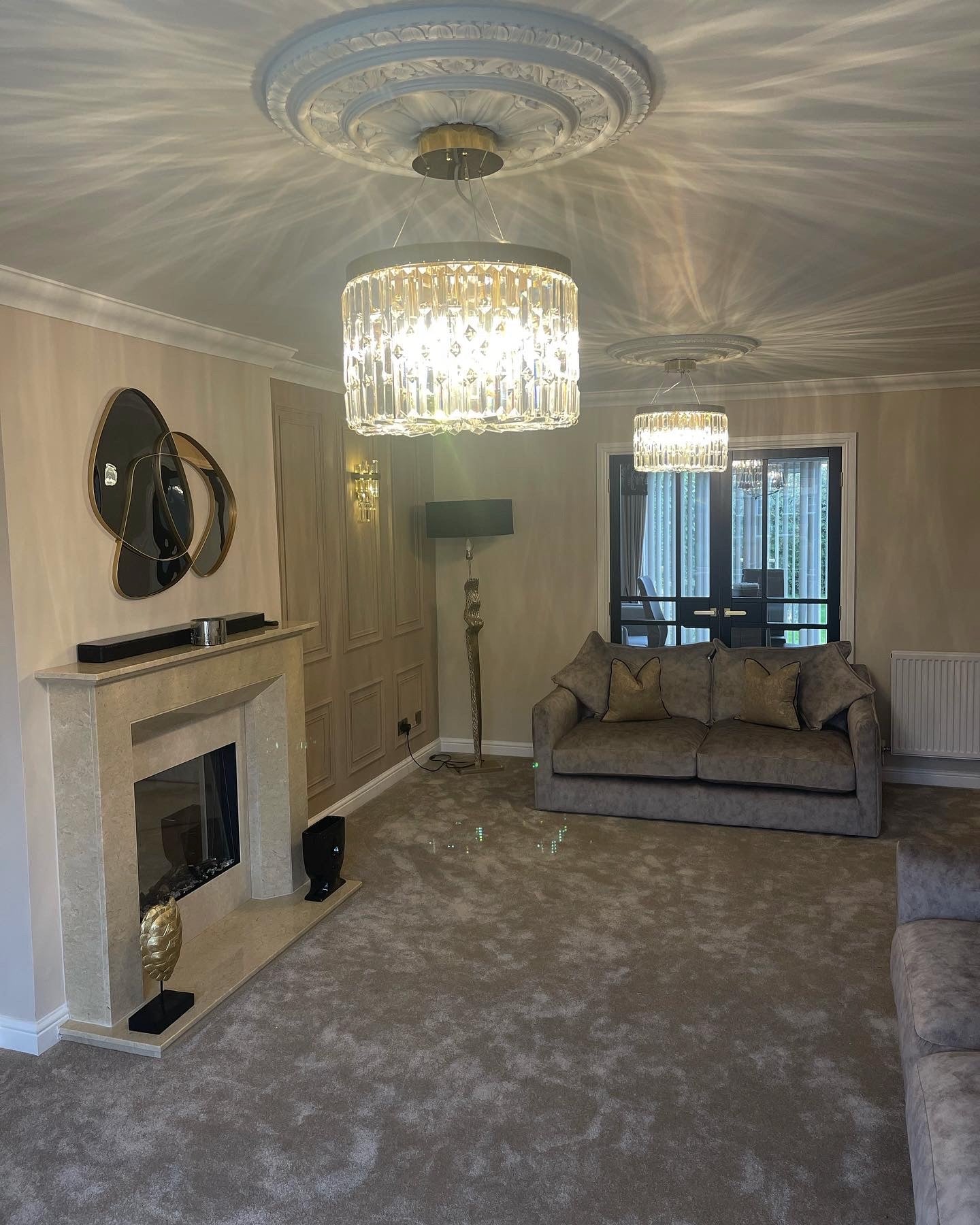 Fira circular crystal chandelier illuminating an elegant living room with soft ambient luxury lighting