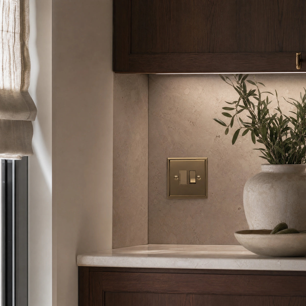Luxury antique brass fused spur installed within discreet below-cabinet utility or kitchen appliance zone in a high-end residence in a UHNW interior by VORELLI®.