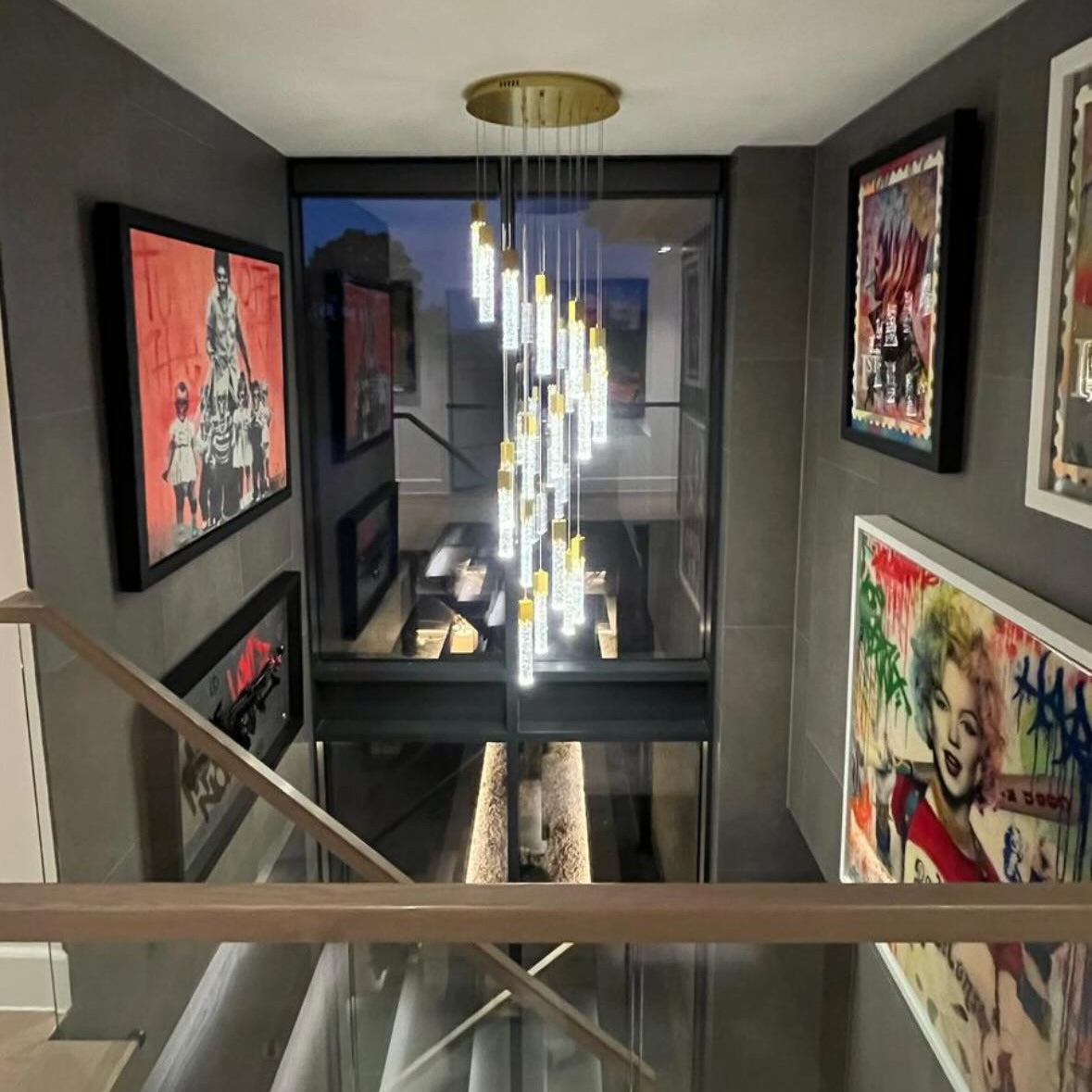 Halstead pendant staircase chandelier with cascading illuminated crystal tubes in a contemporary double-height stairwell