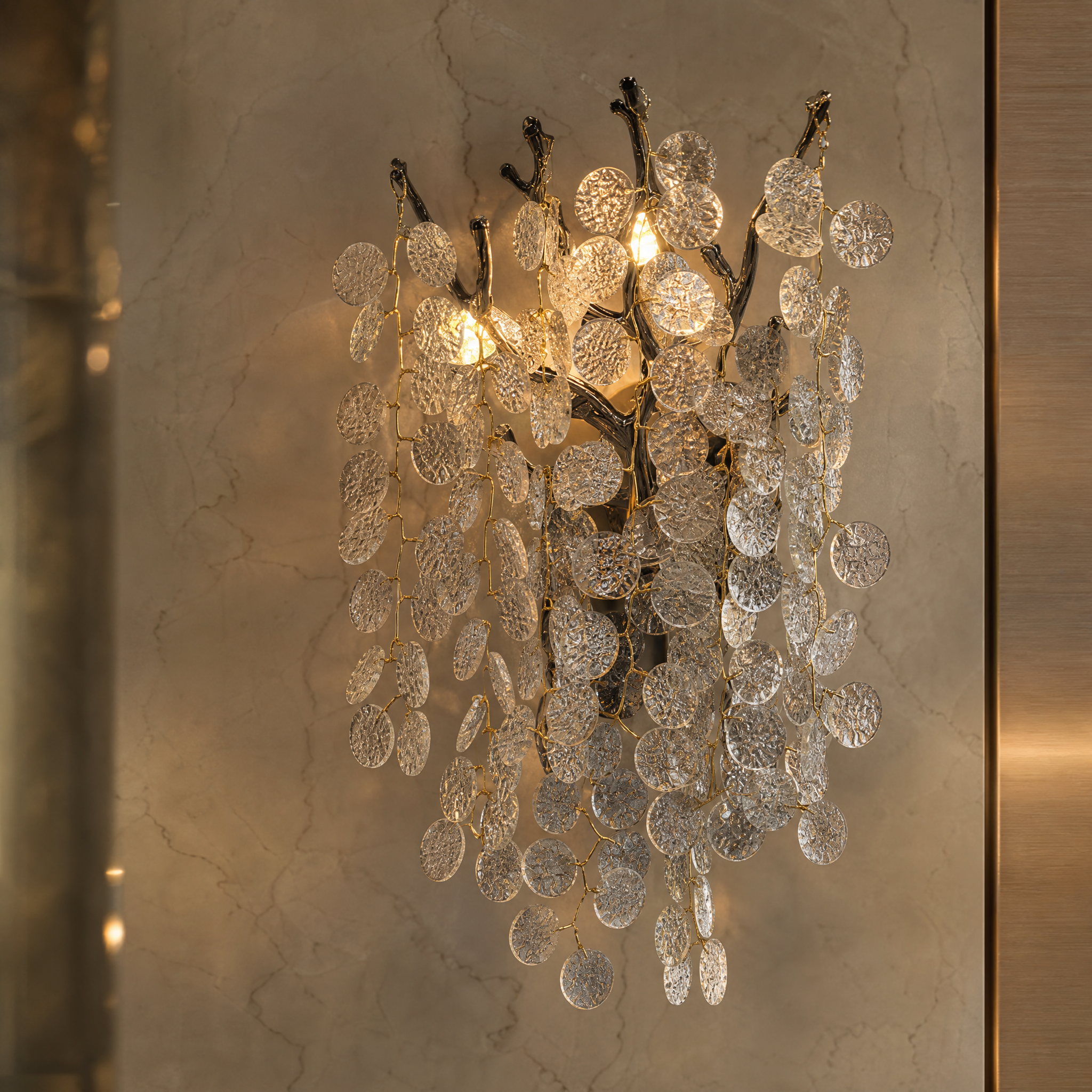 A detailed closeup of the VORELLI Lunaria Wall Light II, showcasing the intricate texture of the cascading glass discs and sculptural metal branches.