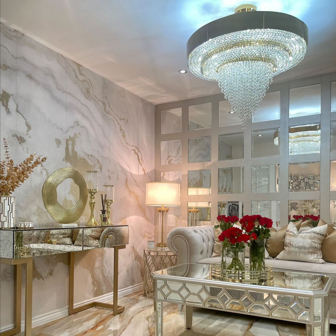 VORELLI® Champs Elysees circular crystal chandelier illuminating a luxury living room with mirrored panels and warm gold tones