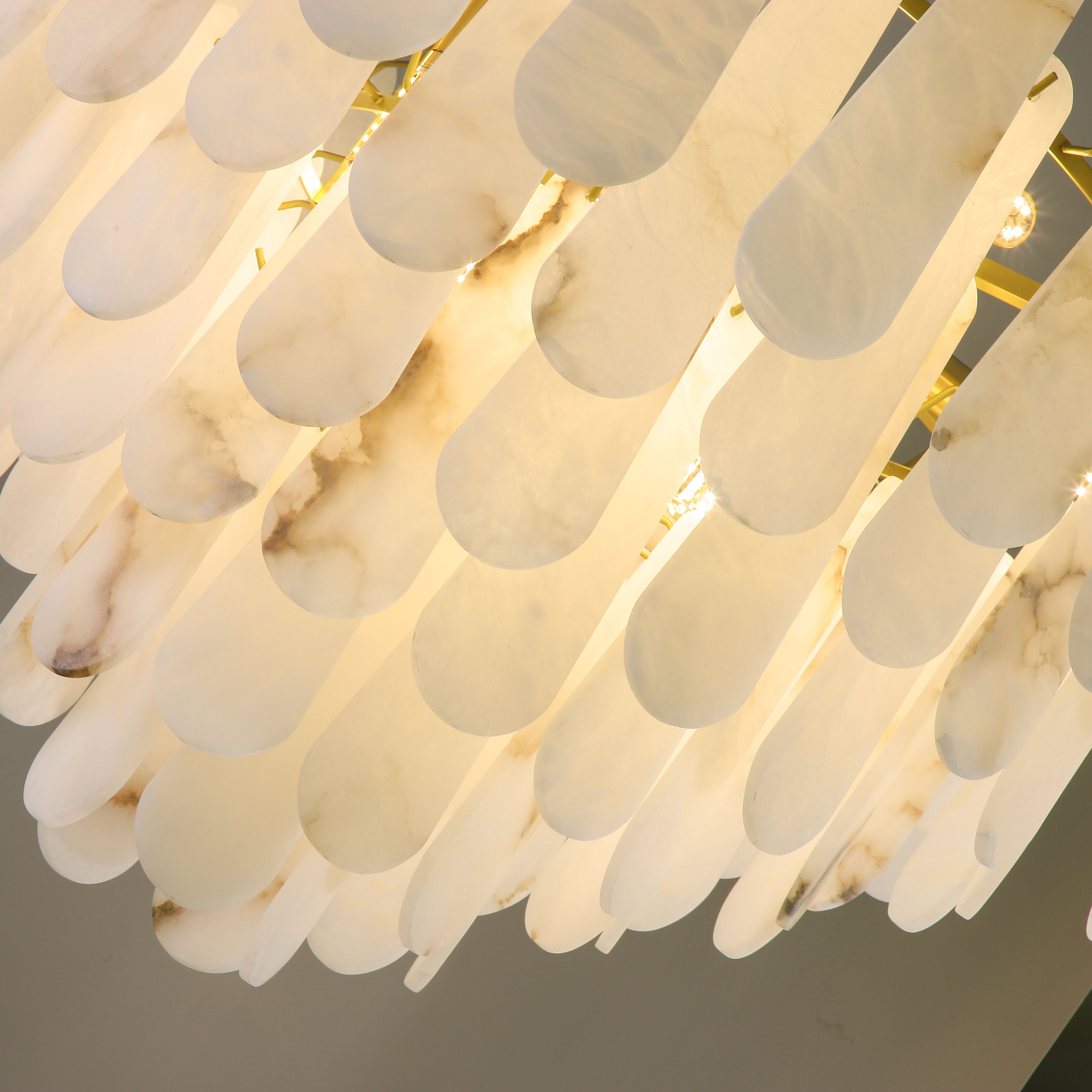 Layered natural marble drops arranged in a circular formation on the VORELLI Maretto chandelier
