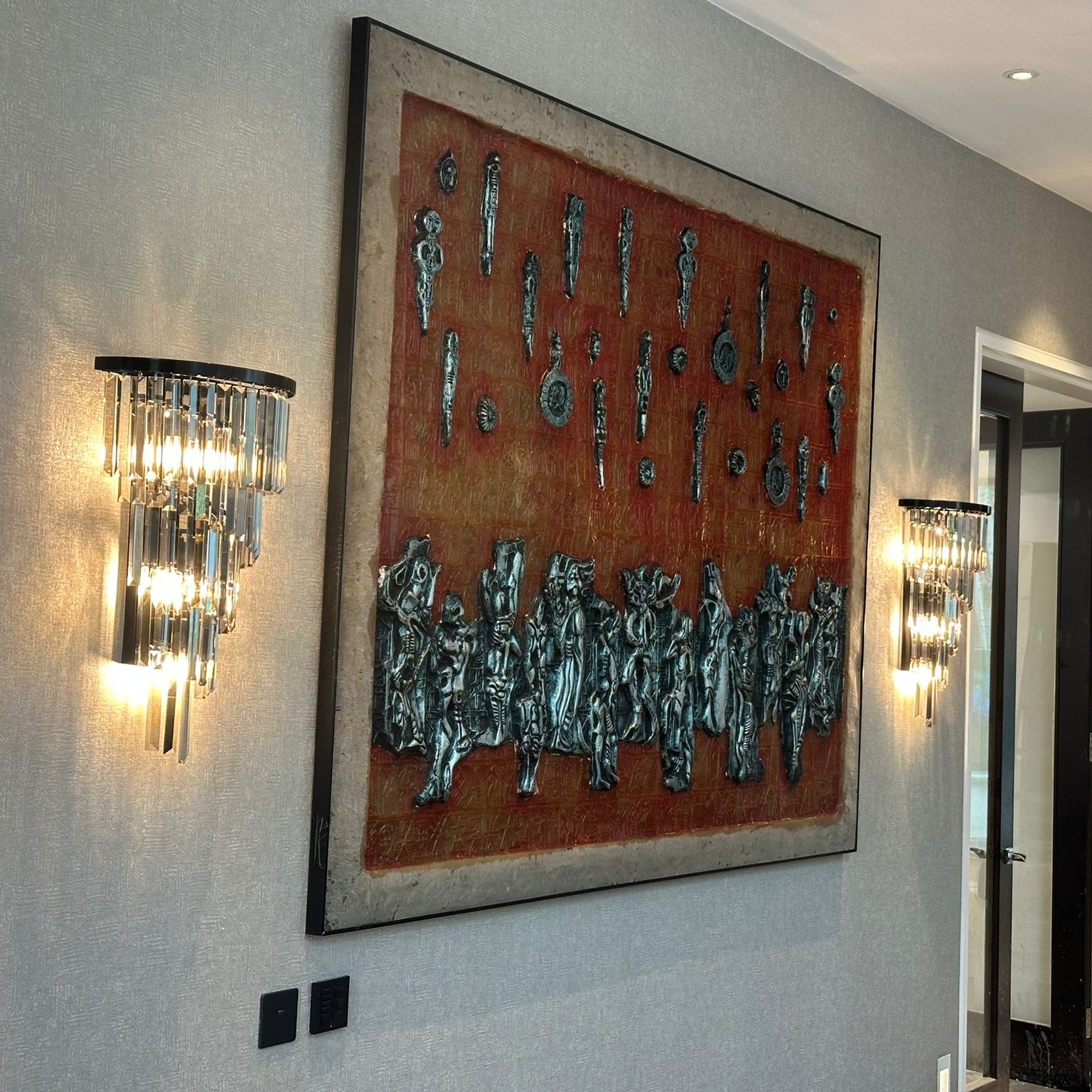 VORELLI Margoux wall light installed in a luxury interior hallway featuring tiered smoky grey crystal bars and warm ambient illumination