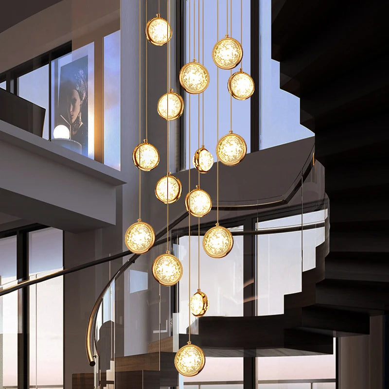 Luxury glass sphere pendant staircase chandelier by VORELLI® illuminating a curved stairwell in a refined residential interior