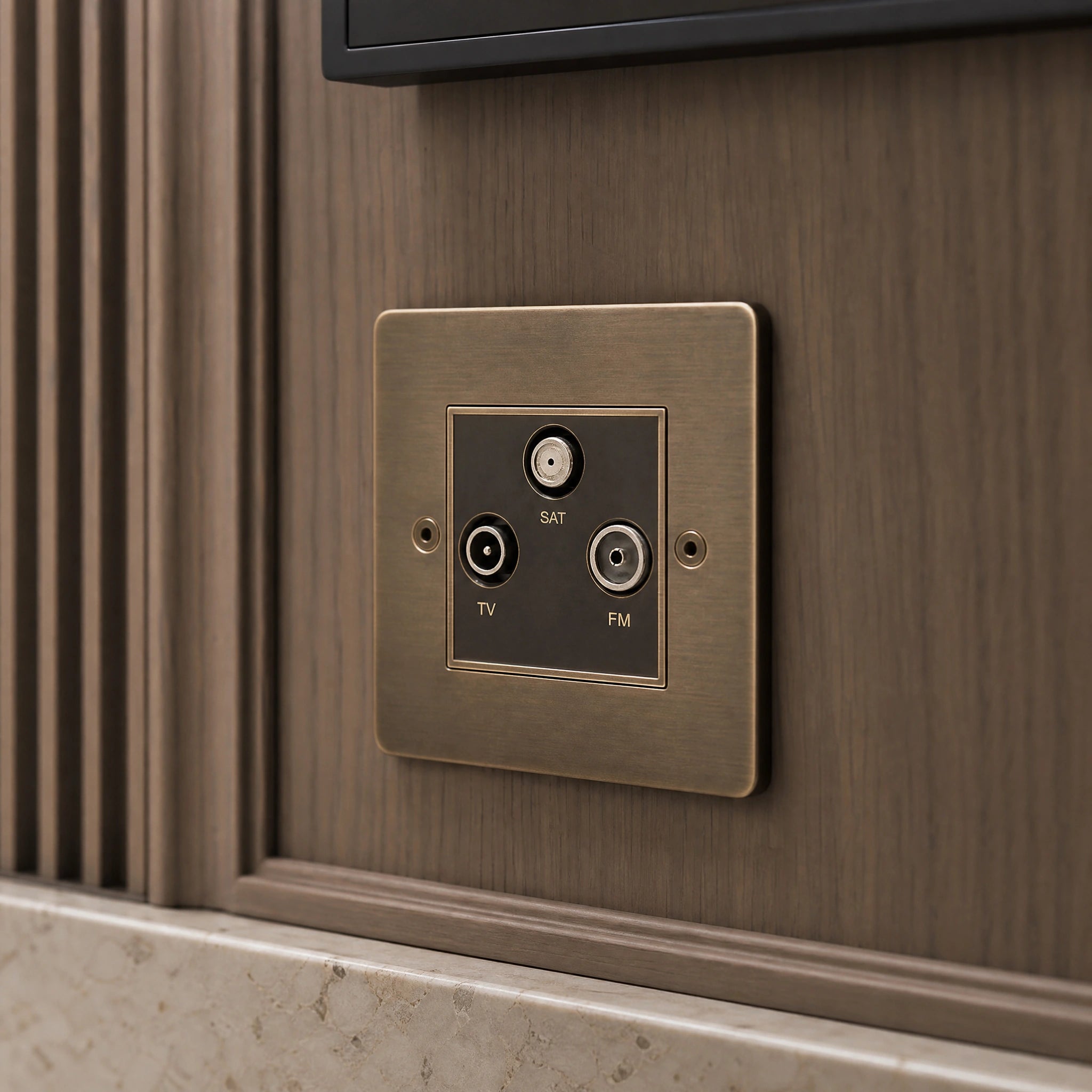 Close-up of a luxury antique brass media outlet installed within bespoke media wall or integrated TV joinery in a private residence by VORELLI®.
