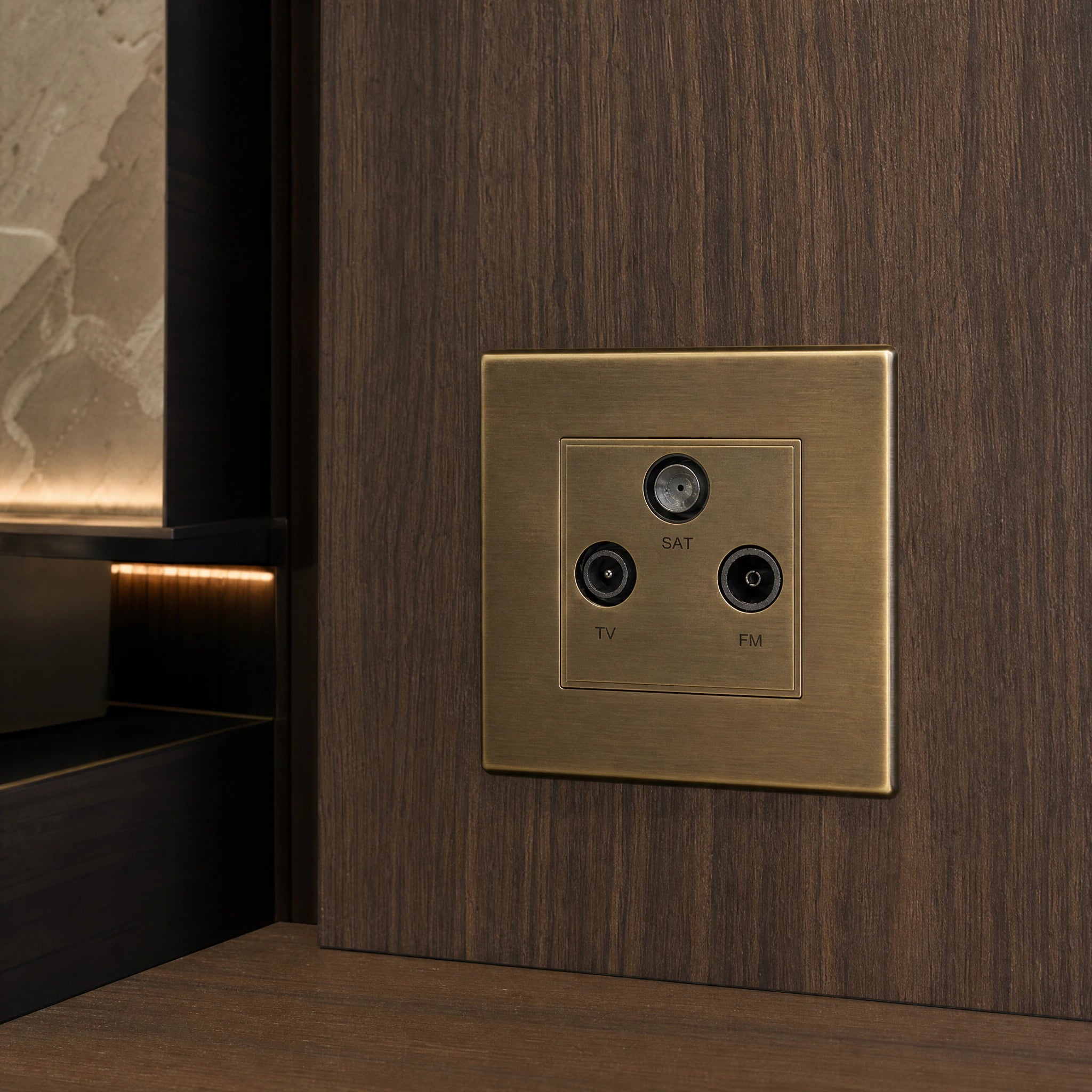 Close-up of a luxury antique brass media outlet installed within bespoke media wall or integrated TV joinery in a private residence by VORELLI®.