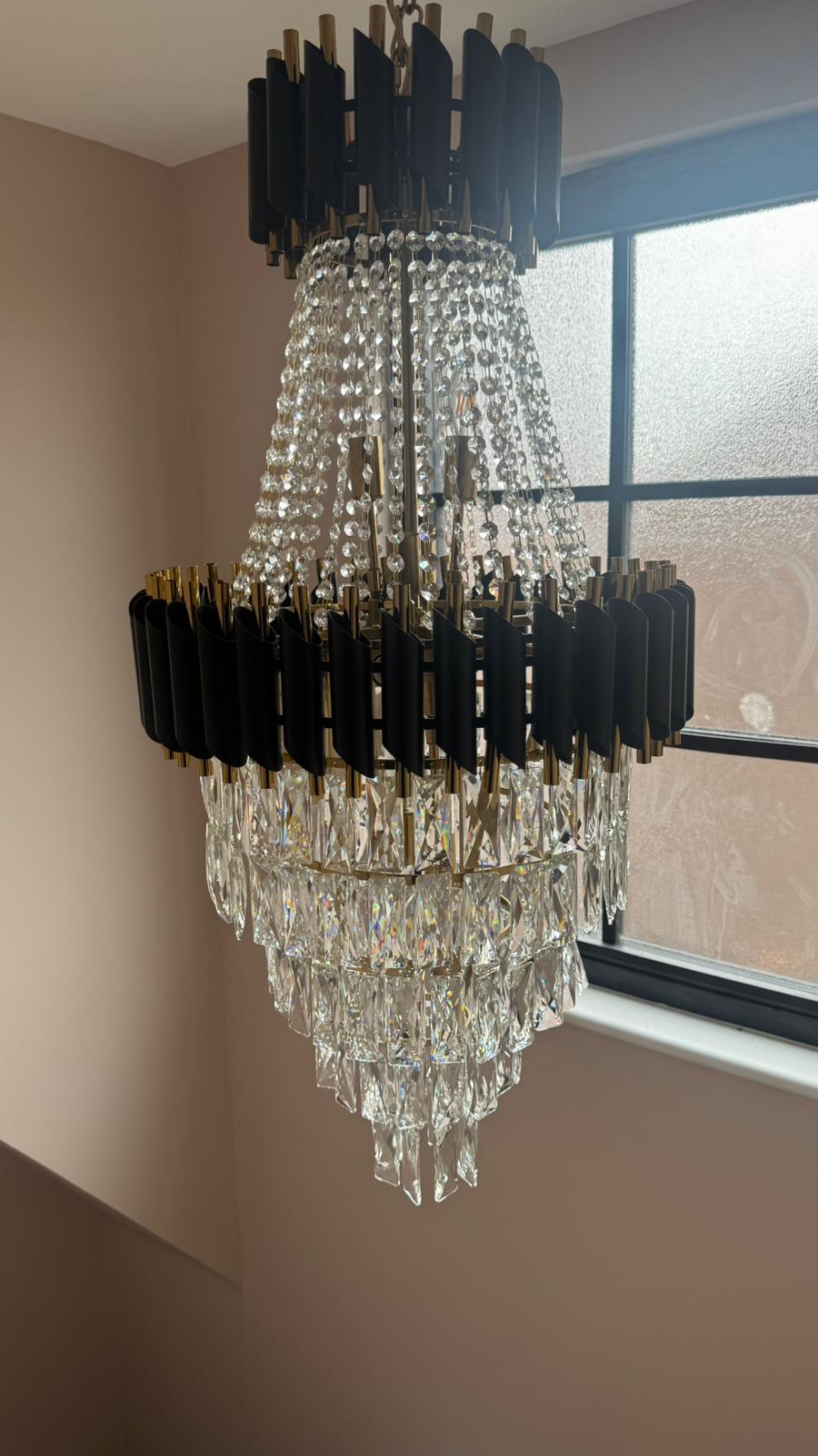 Close-up of bold architectural fins surrounding crystal drops on the VORELLI Milltimber Grandeur staircase chandelier