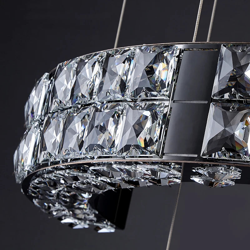 Close-up crystal detail of the VORELLI® Minato pendant staircase chandelier showing illuminated faceted elements and refined luxury craftsmanship