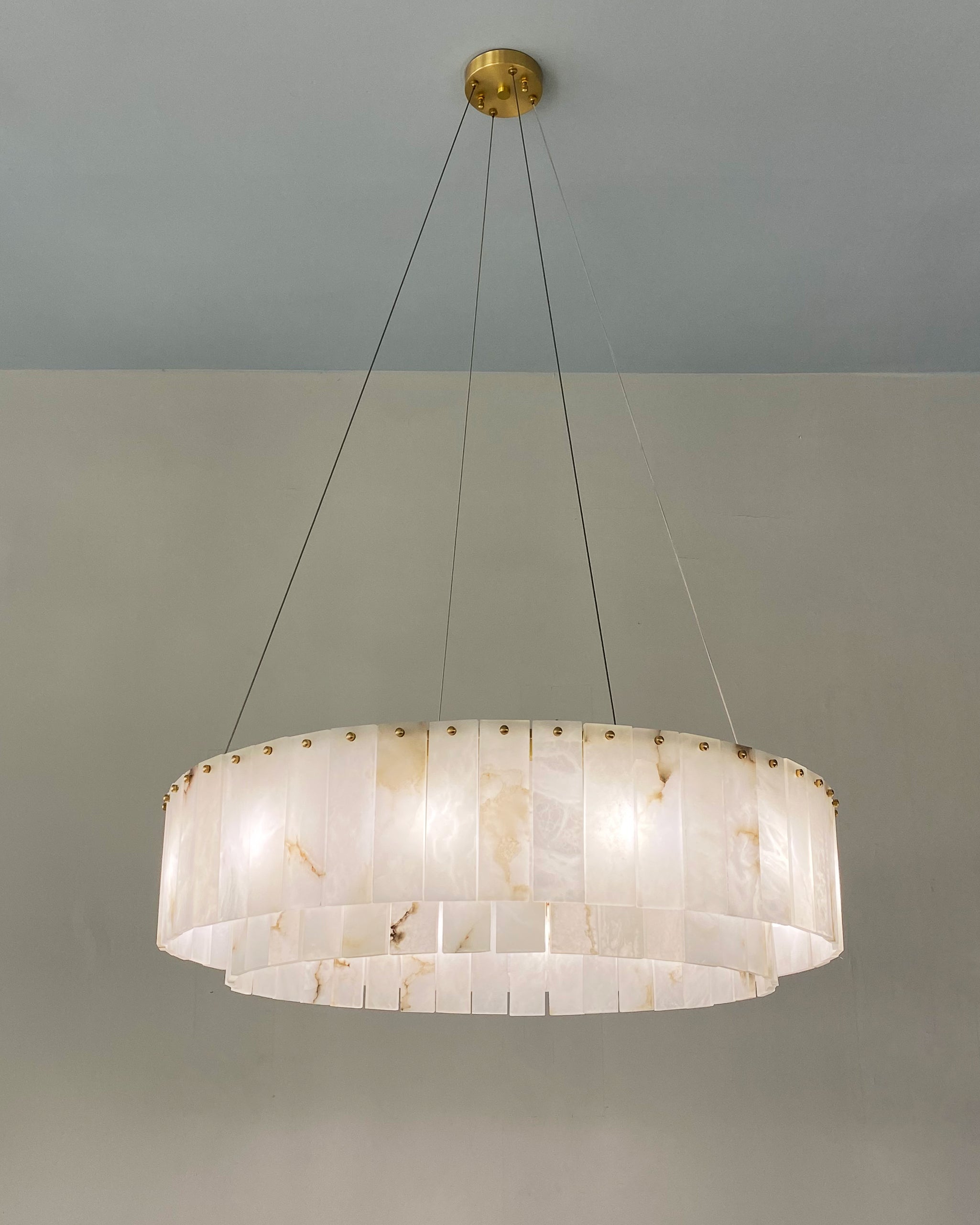 VORELLI® Munro marble chandelier suspended above dining table creating soft natural glow in contemporary interior