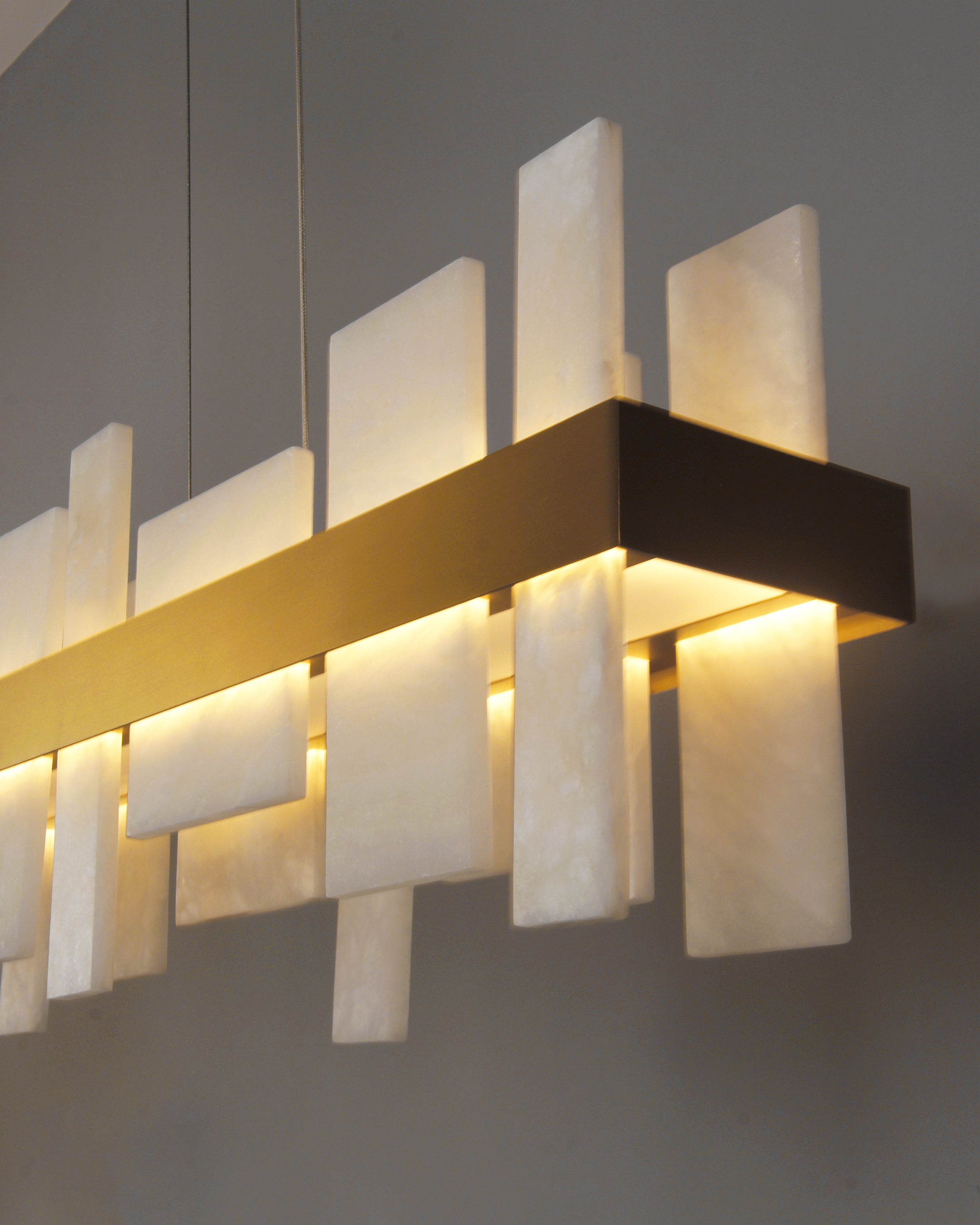 Close up of VORELLI® Niva marble rectangular chandelier highlighting layered natural stone panels integrated within sleek linear frame