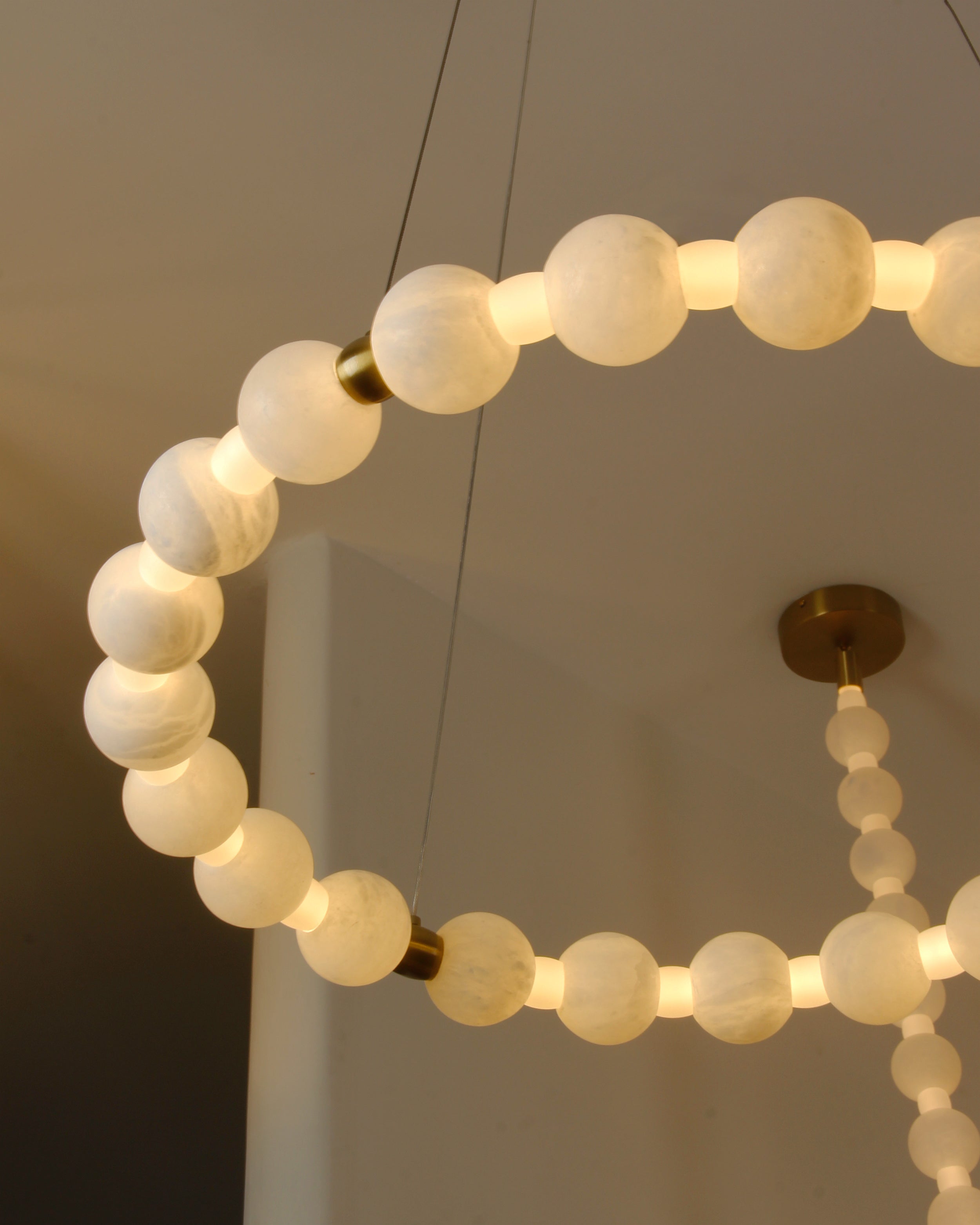 Detailed view of circular ring structure and marble spheres on VORELLI® Orbella chandelier
