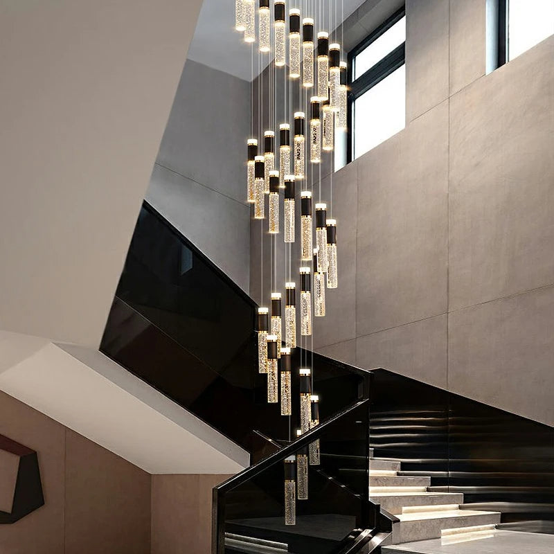 Designer staircase lighting by VORELLI® with cascading crystal pendants enhancing high ceilings, villas, and sophisticated residential interiors