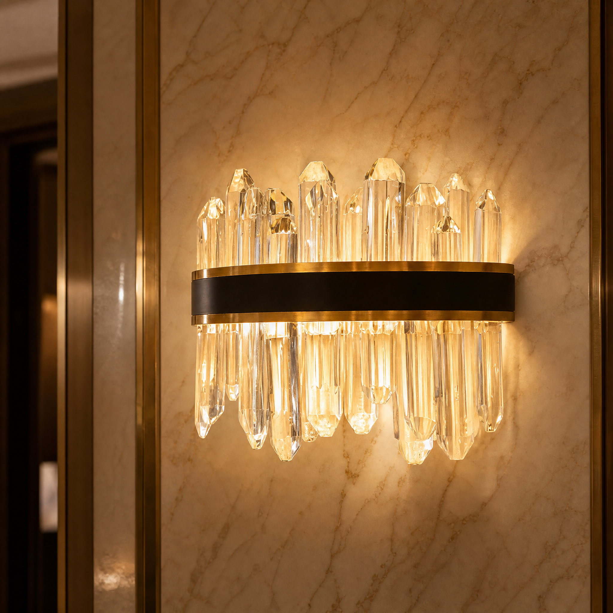 Close-up detail of the VORELLI Sagres wall light, highlighting the diamond cut oblong crystals and the luxurious bold dual finish of matte black and brushed titanium gold.