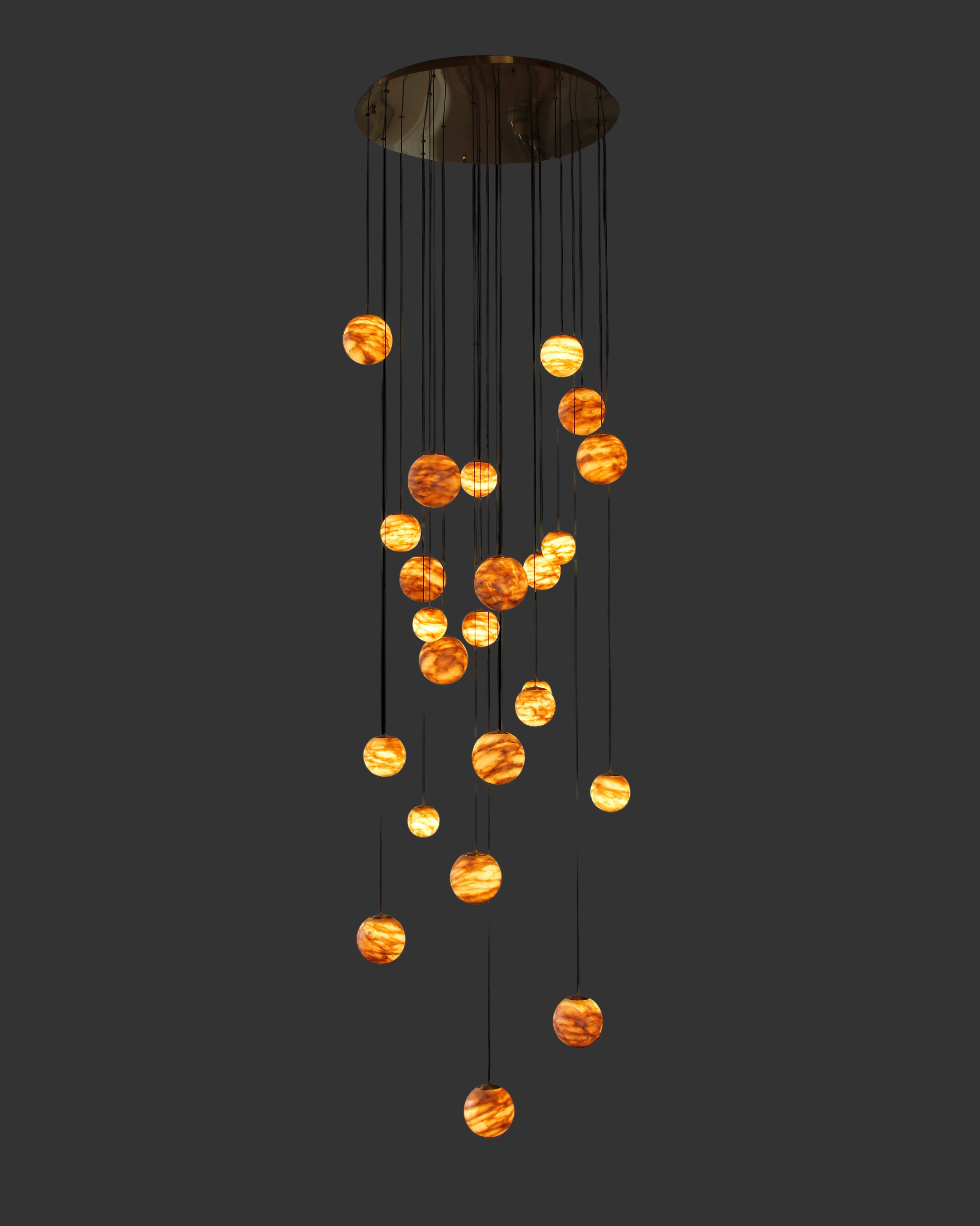 Luxury marble stairwell chandelier by VORELLI® featuring suspended illuminated spheres designed for double-height residential and hospitality spaces