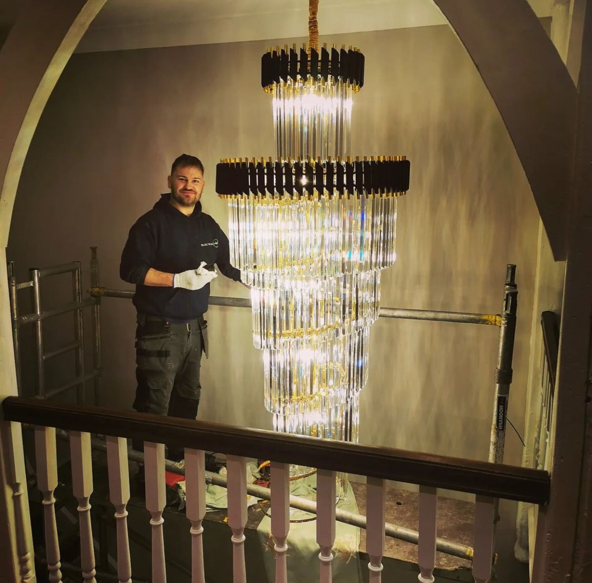Large luxury staircase chandelier by VORELLI® shown in situ to demonstrate scale and vertical impact