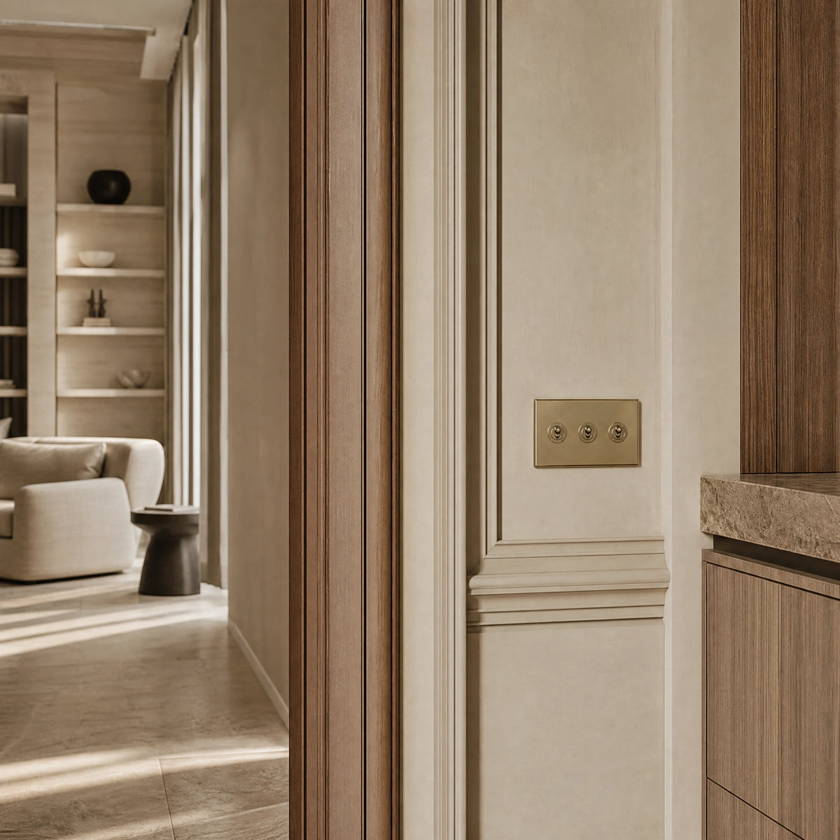 Luxury antique brass toggle switch installed within feature wall beside an elegant doorway with refined timber panelling in a UHNW interior by VORELLI®.