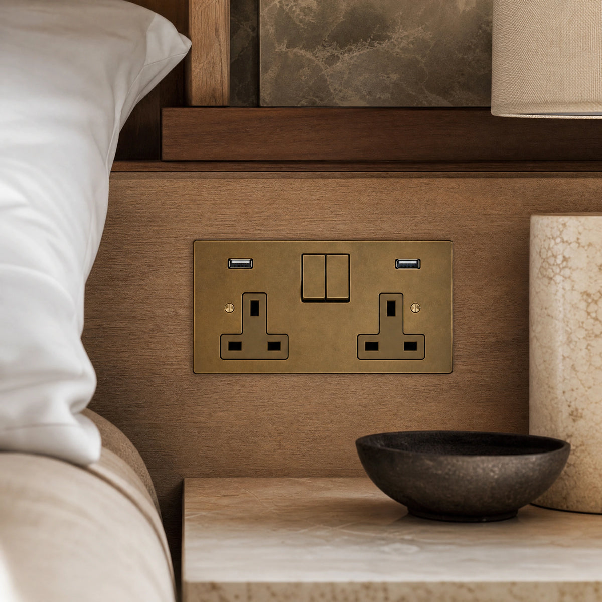 Close-up of a luxury antique brass usb socket installed within bespoke bedside joinery in a luxury bedroom suite by VORELLI®.