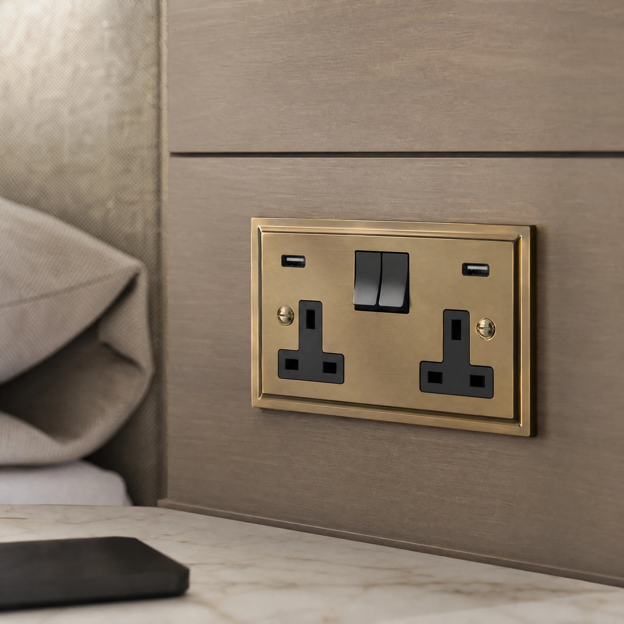 Close-up of a luxury antique brass usb socket installed within bespoke bedside joinery in a luxury bedroom suite by VORELLI®.