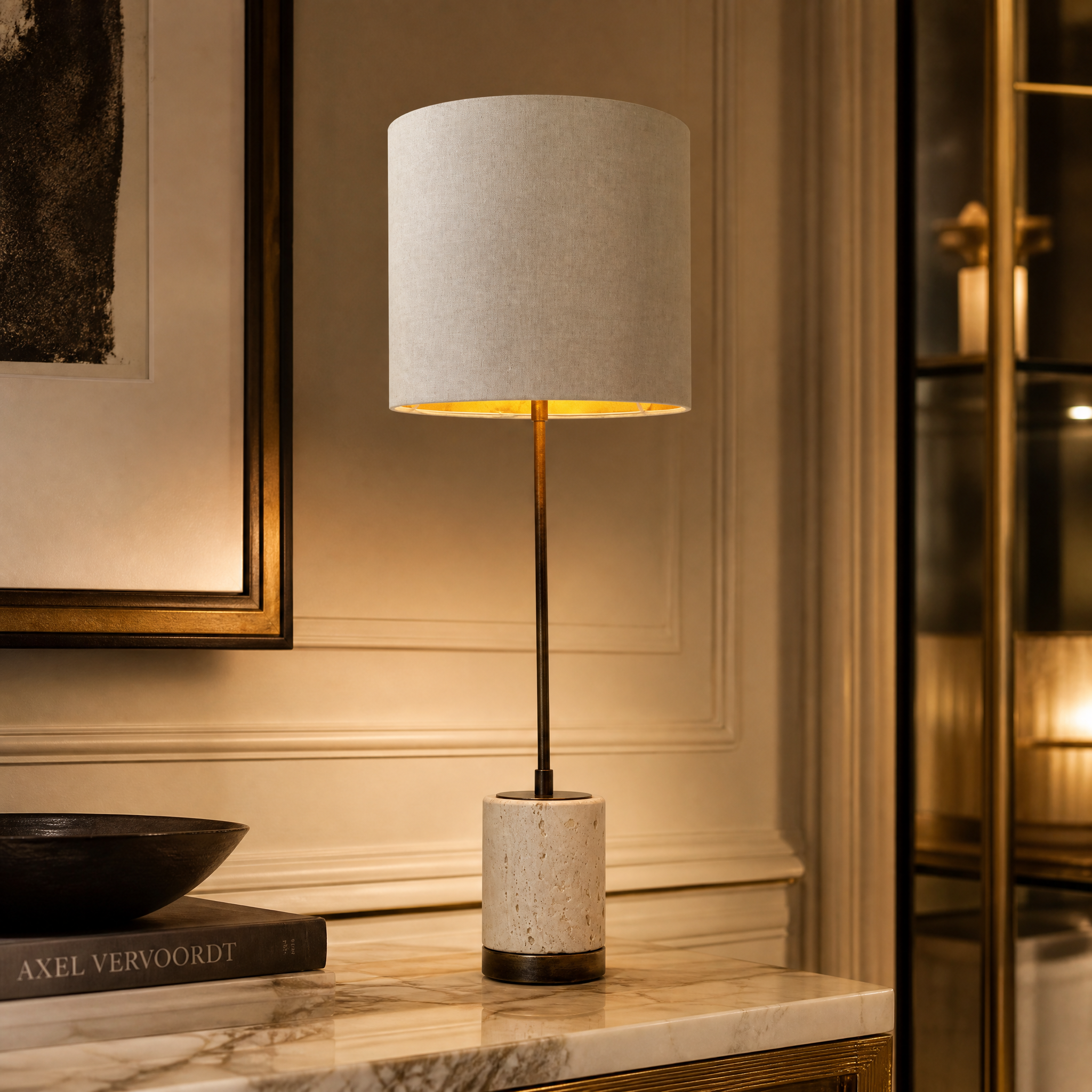 A detailed closeup of the VORELLI Valmere H71 lamp showcasing its slender antique brass stem and natural textured travertine base.
