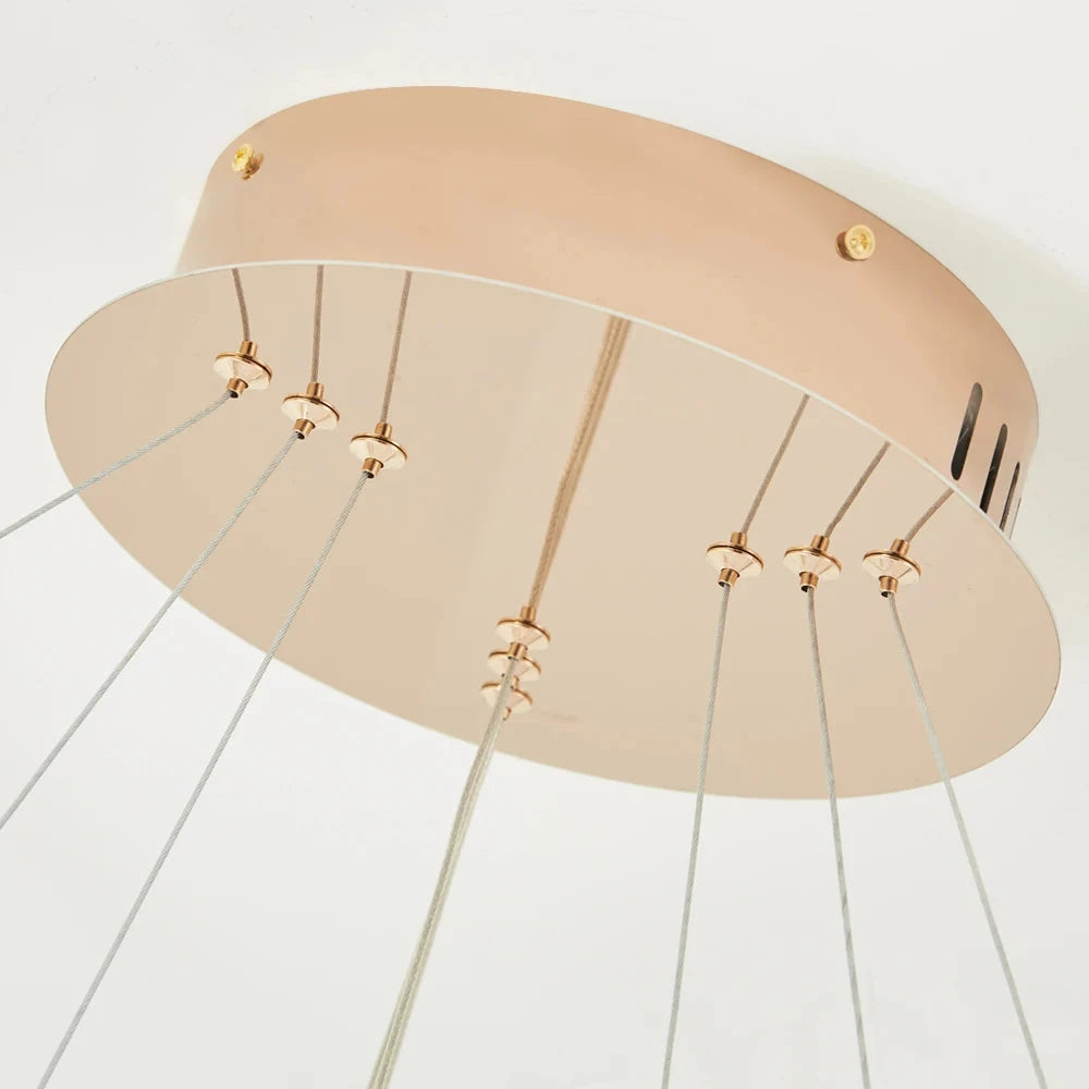Detail of ceiling plate and suspension wires on circular LED chandelier for clean modern installation