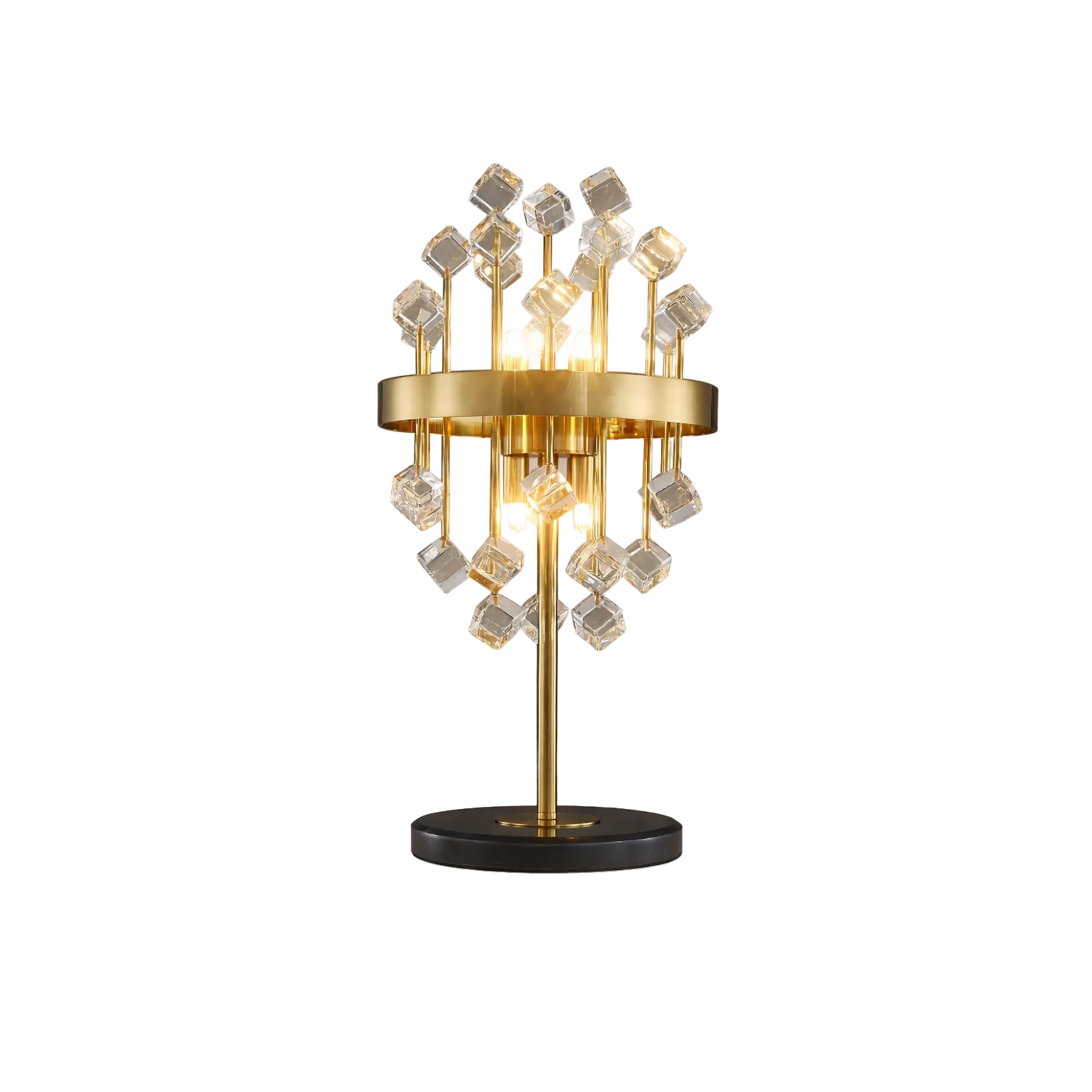 Luxury gold table lamp with clear crystal cube accents and warm glowing bulbs, placed on a bedside table in a modern bedroom interior with neutral tones and decorative vase.