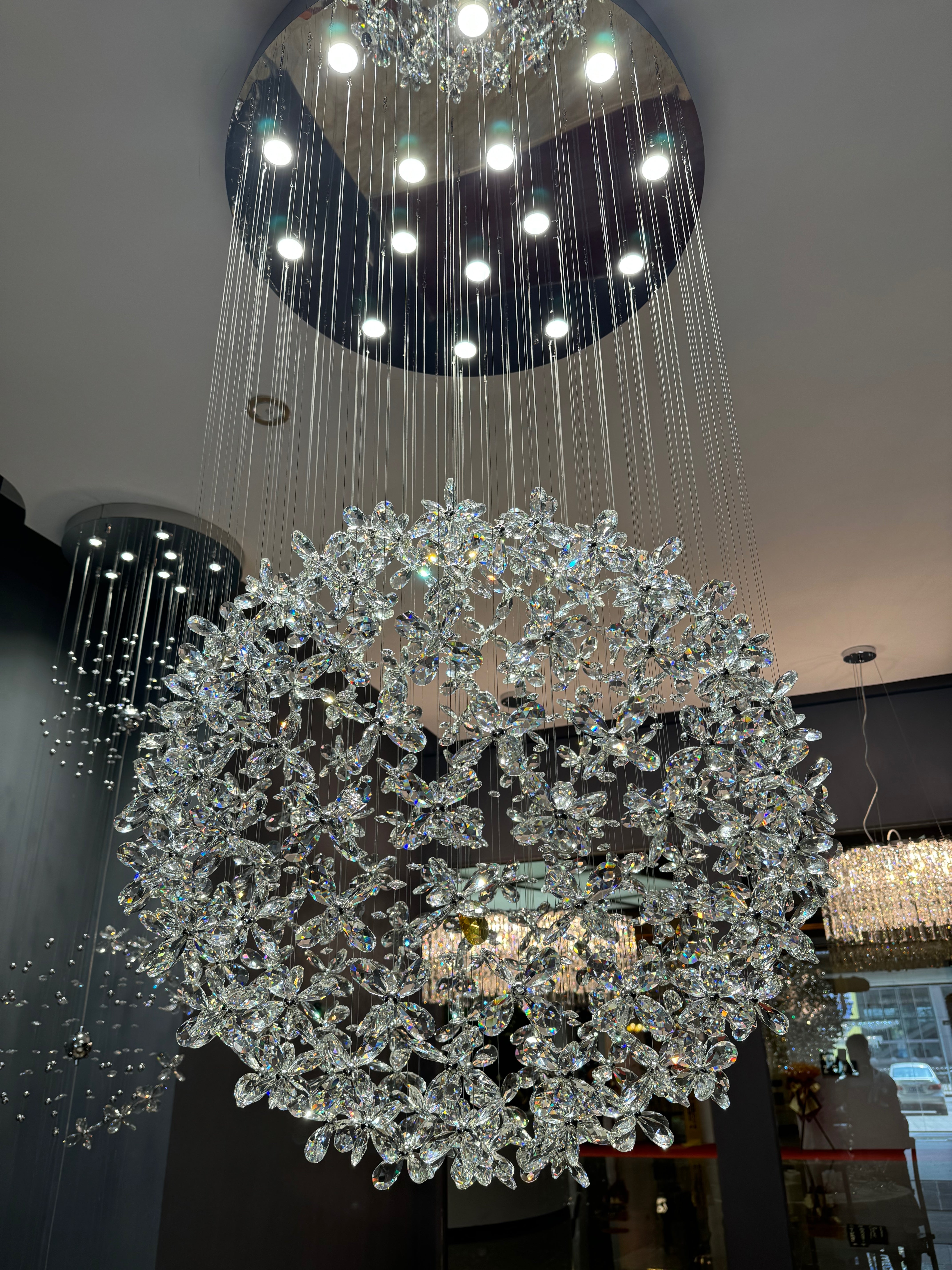 Luxury staircase chandelier with cascading diamond cut flower crystals in a spherical formation