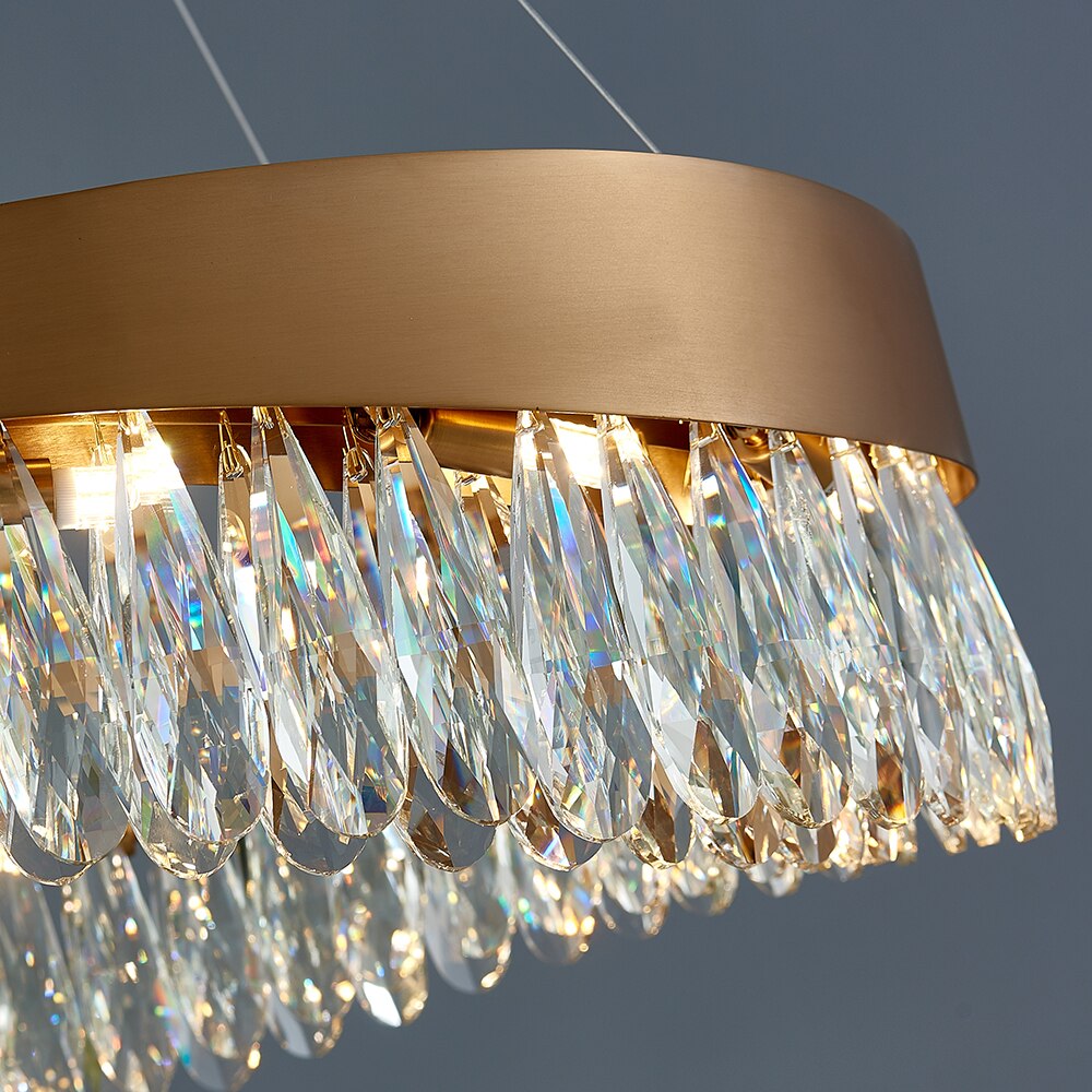 Close-up of diamond cut teardrop crystals arranged around a circular gold frame chandelier