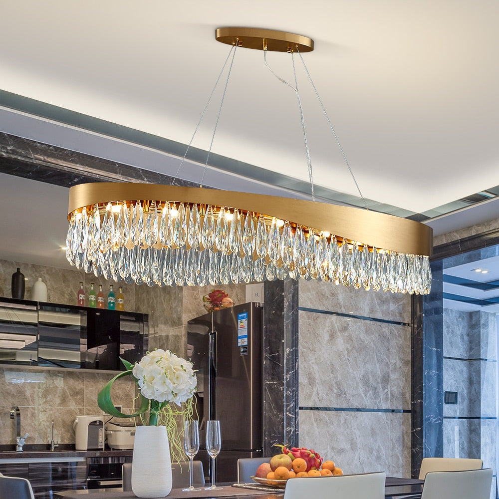 Lomazzo rectangular chandelier with diamond cut teardrop crystals suspended above a luxury modern kitchen island