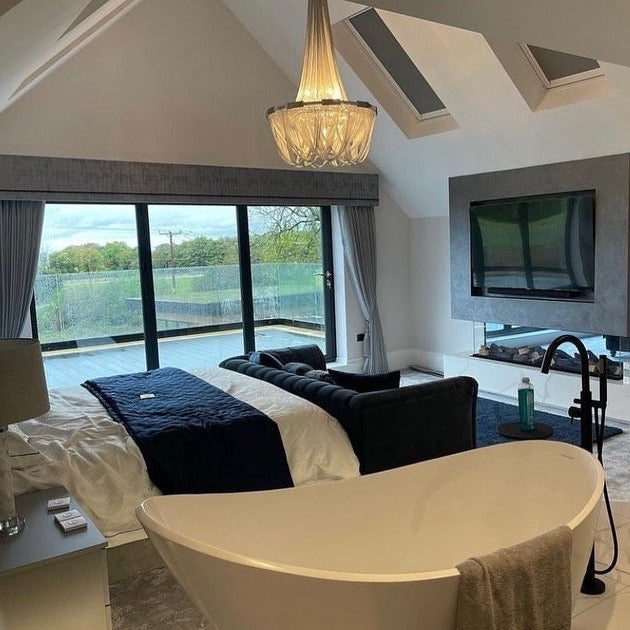 Adlington Grandeur staircase chandelier illuminating a luxury bedroom with flowing crystal chains and refined architectural detailing