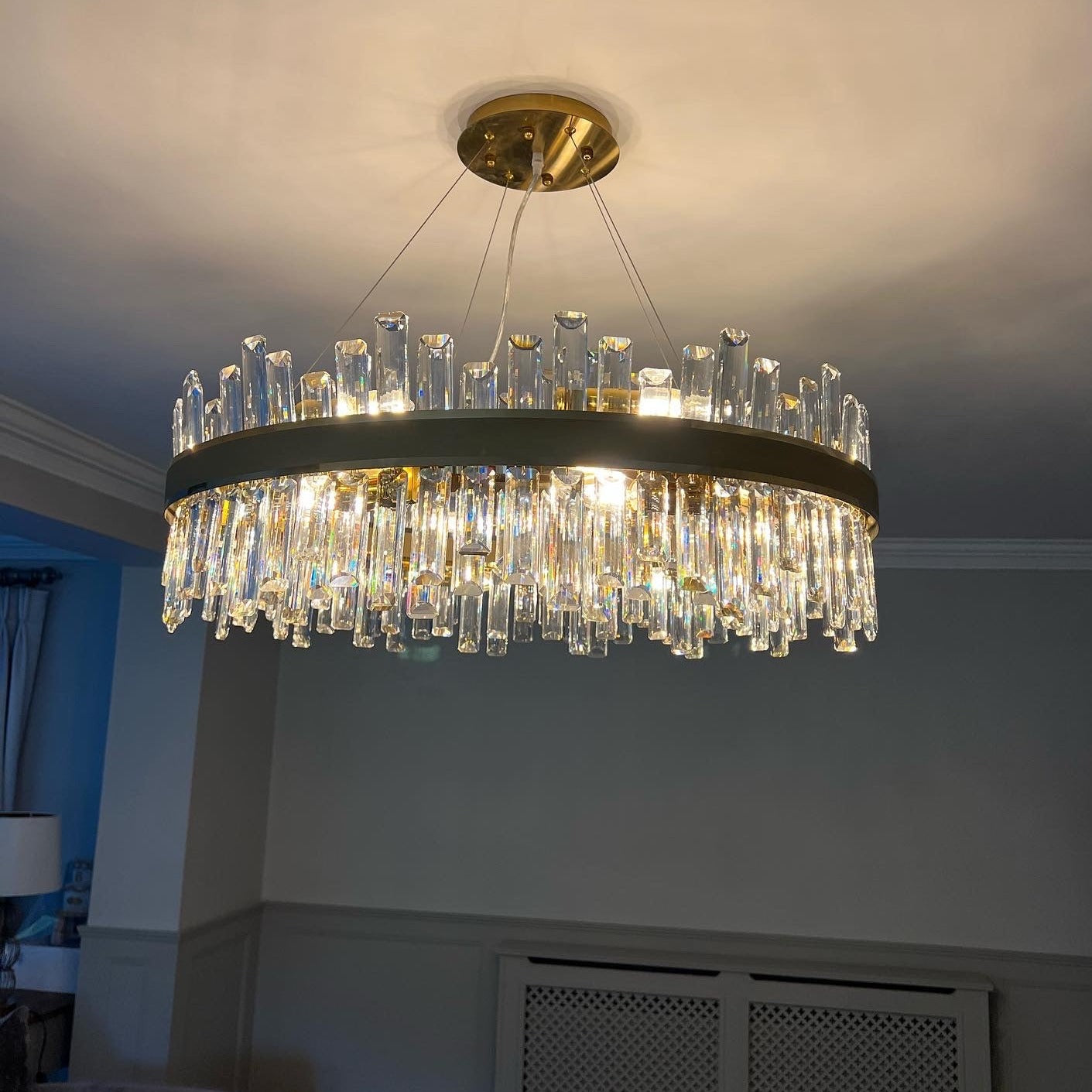 Brighouse Circular Chandelier casting warm ambient light through its rounded rectangle crystal prisms.
