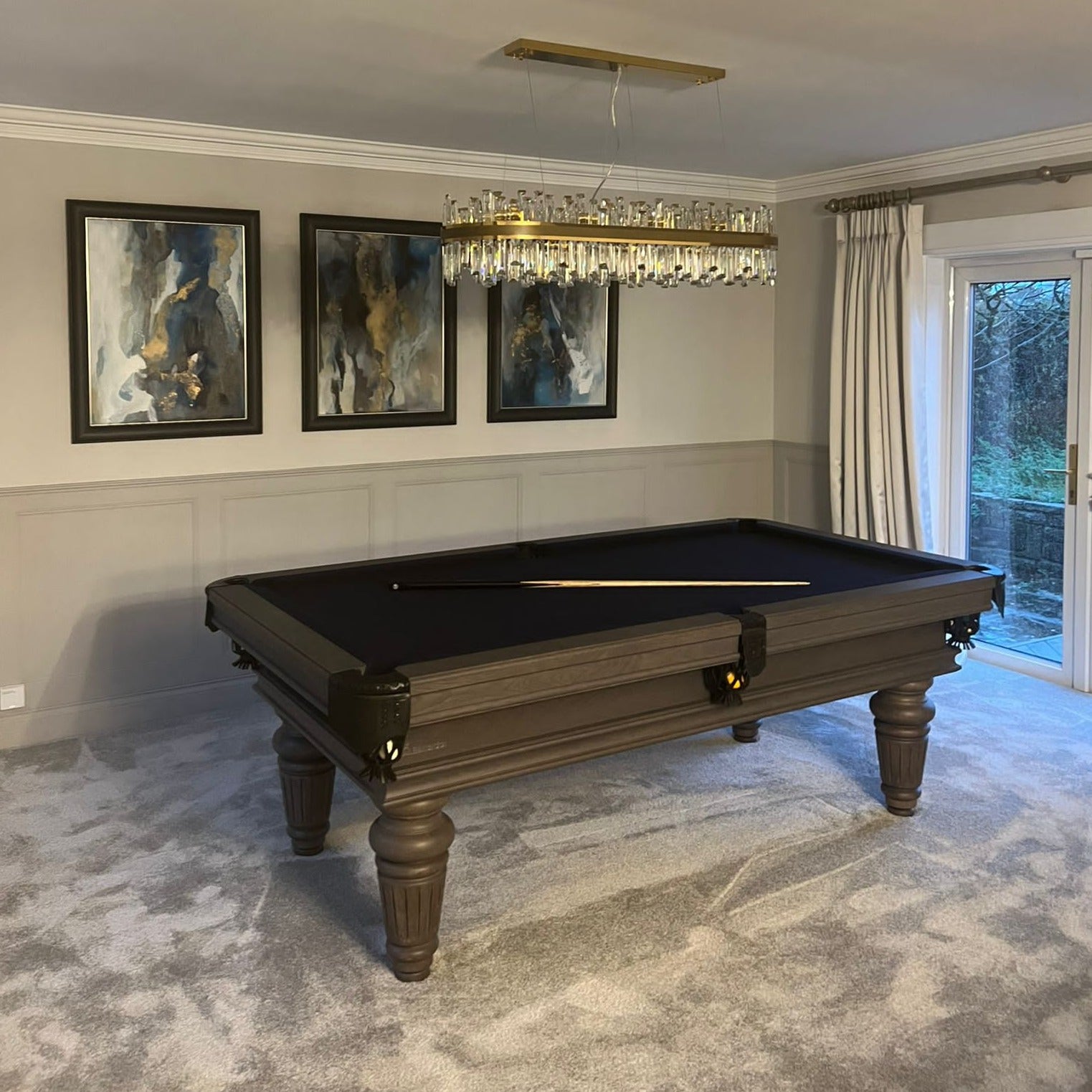 Brighouse Rectangular Chandelier featuring alternating crystal sizes in an elegant entertainment room.