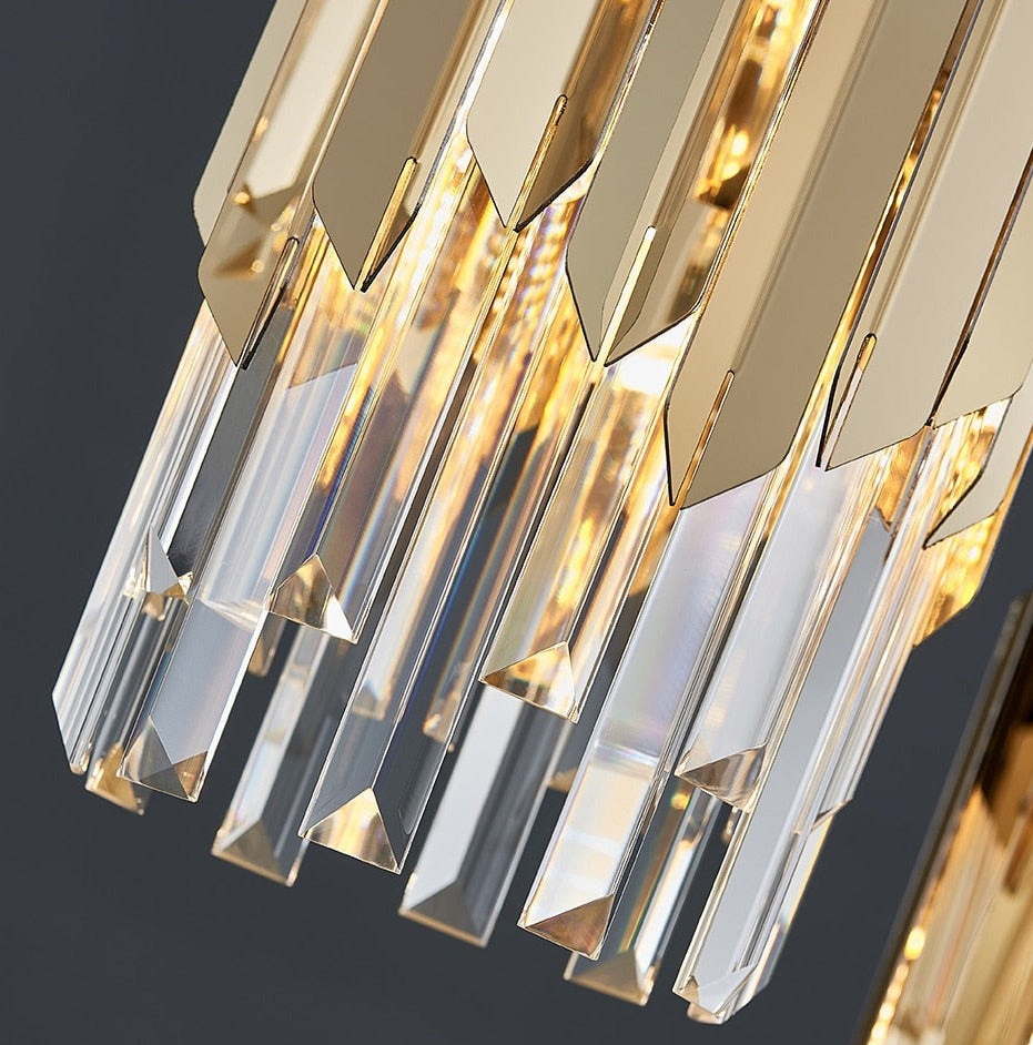 Close-up of VORELLI Manhattan Pendant diamond-cut crystal bars with soft golden glow