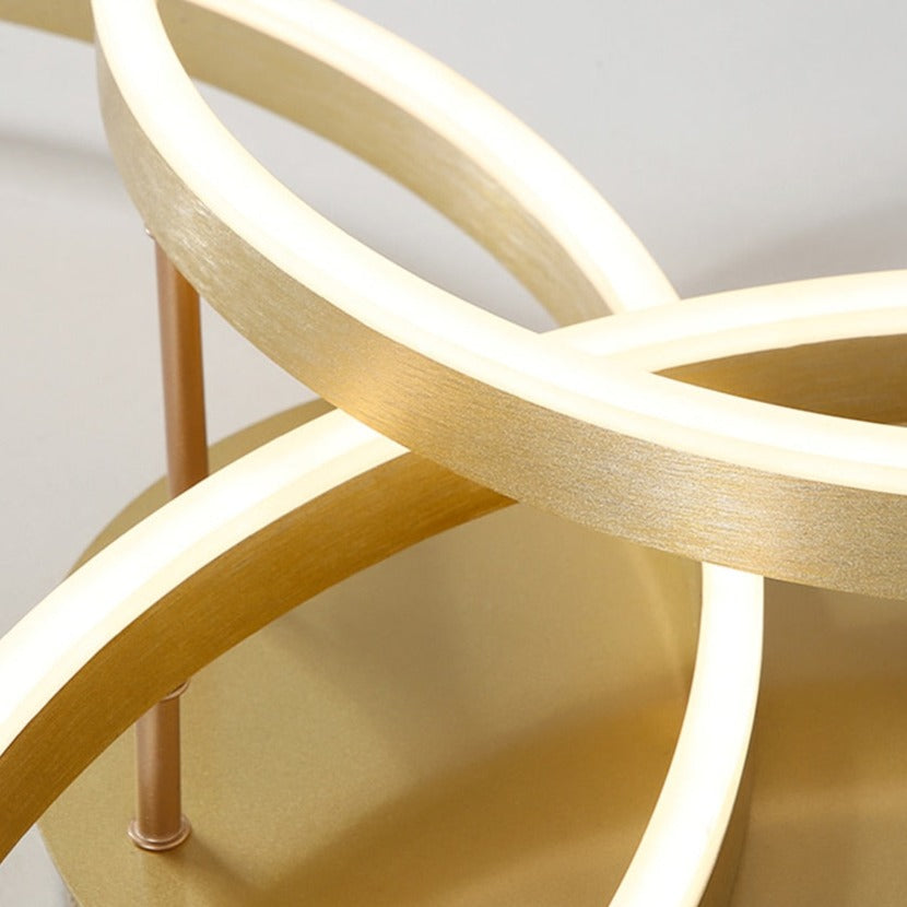 Close-up of intersecting illuminated LED rings on the VORELLI Maumelle ceiling light showing smooth curves and modern sculptural design