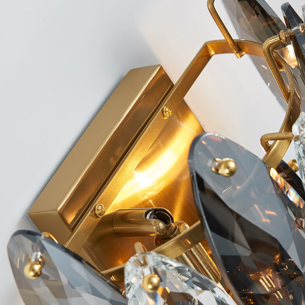 Close up of oval crystal elements and structured frame on VORELLI® Oakhill wall light