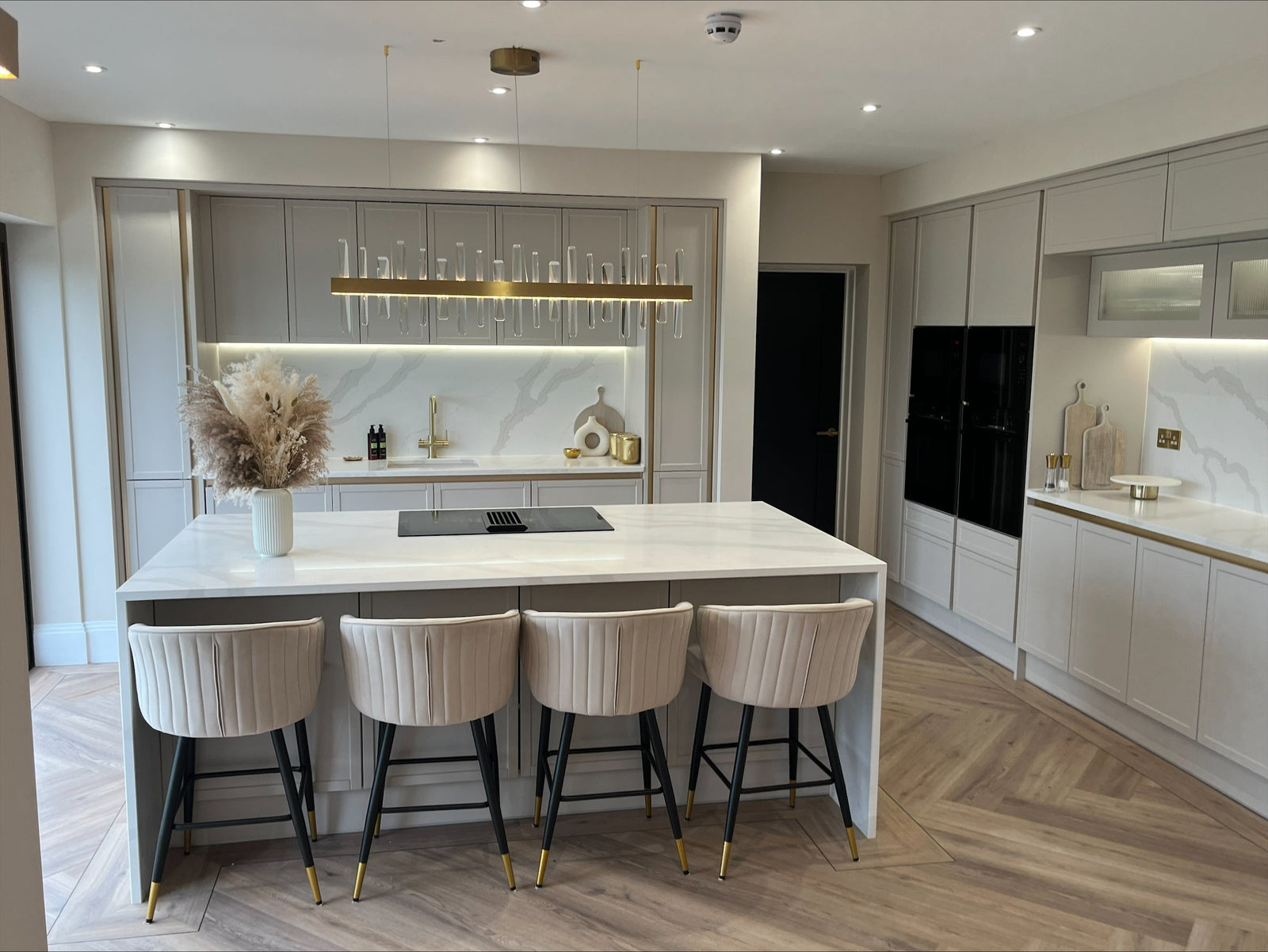 Luxury rectangular chandelier above a kitchen island and dining space by VORELLI