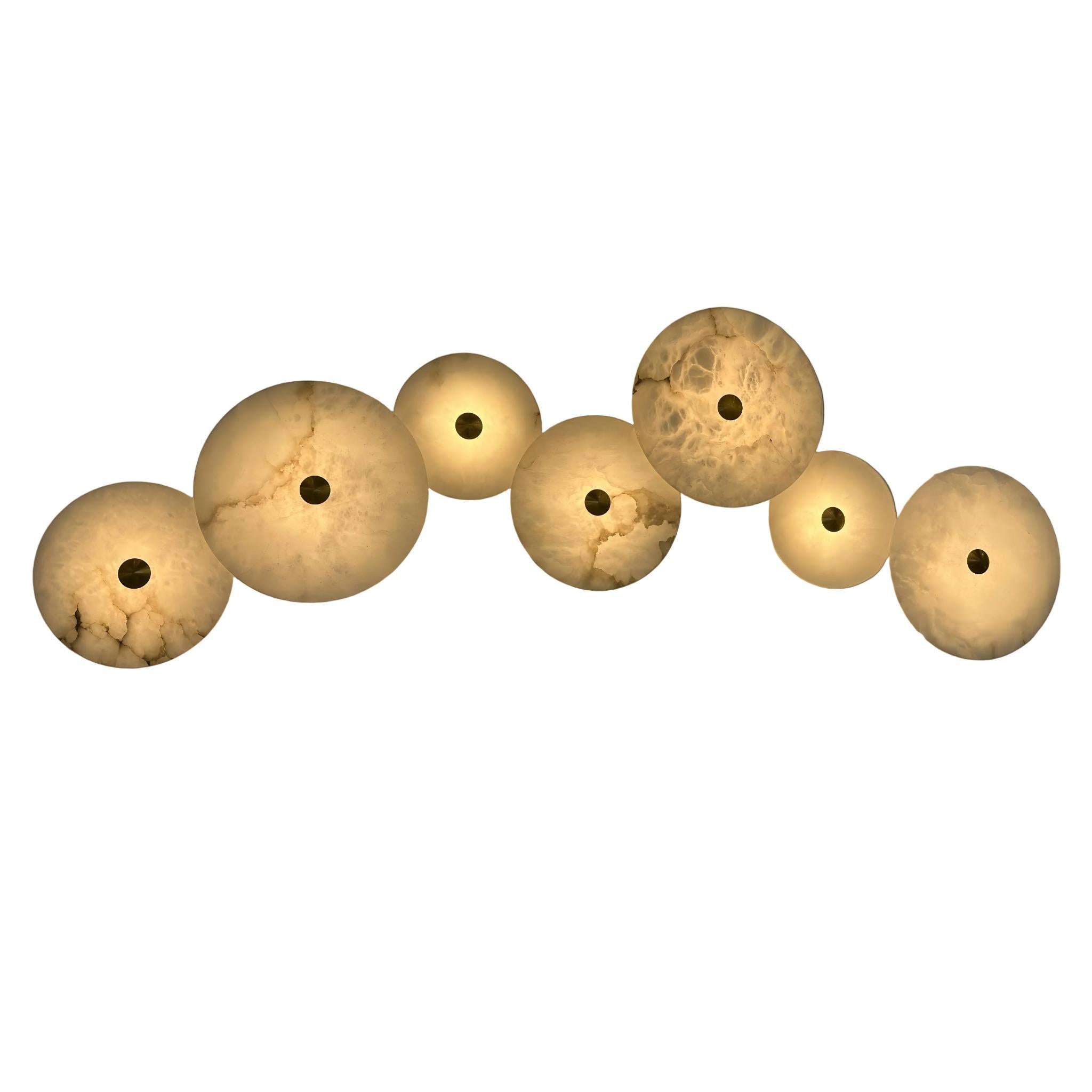 Aria wall lights mounted in a linear formation on a soft grey wall.