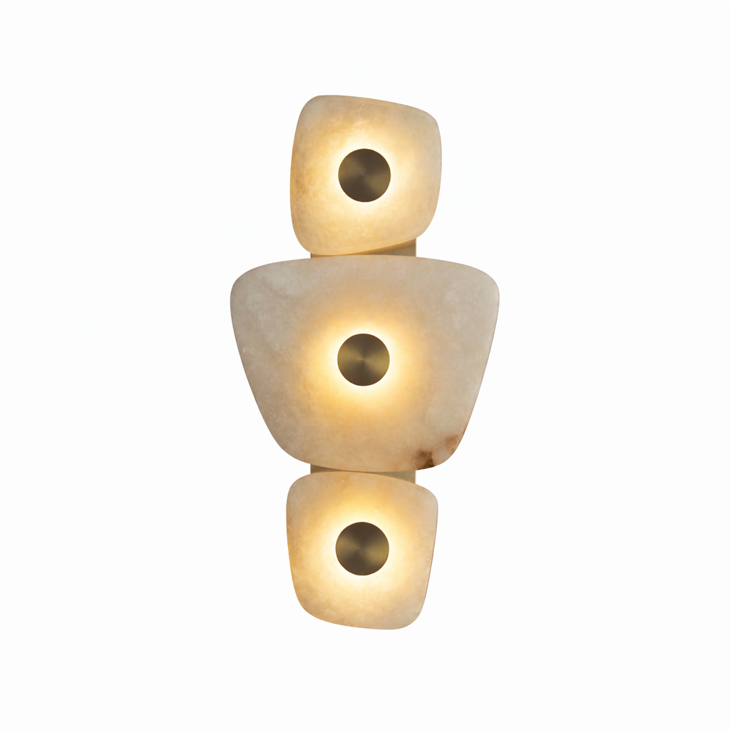 Luxury sculptural marble wall light with stacked illuminated natural stone forms and central circular metal accents, isolated on pure white background