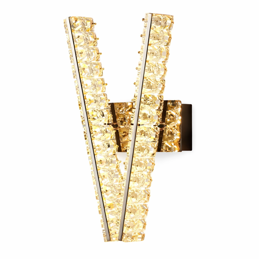A dramatic view of the VORELLI Signature 'V' crystal wall light casting a warm, sophisticated glow, emphasizing the sharp luxury angles and contemporary mood of the fixture.