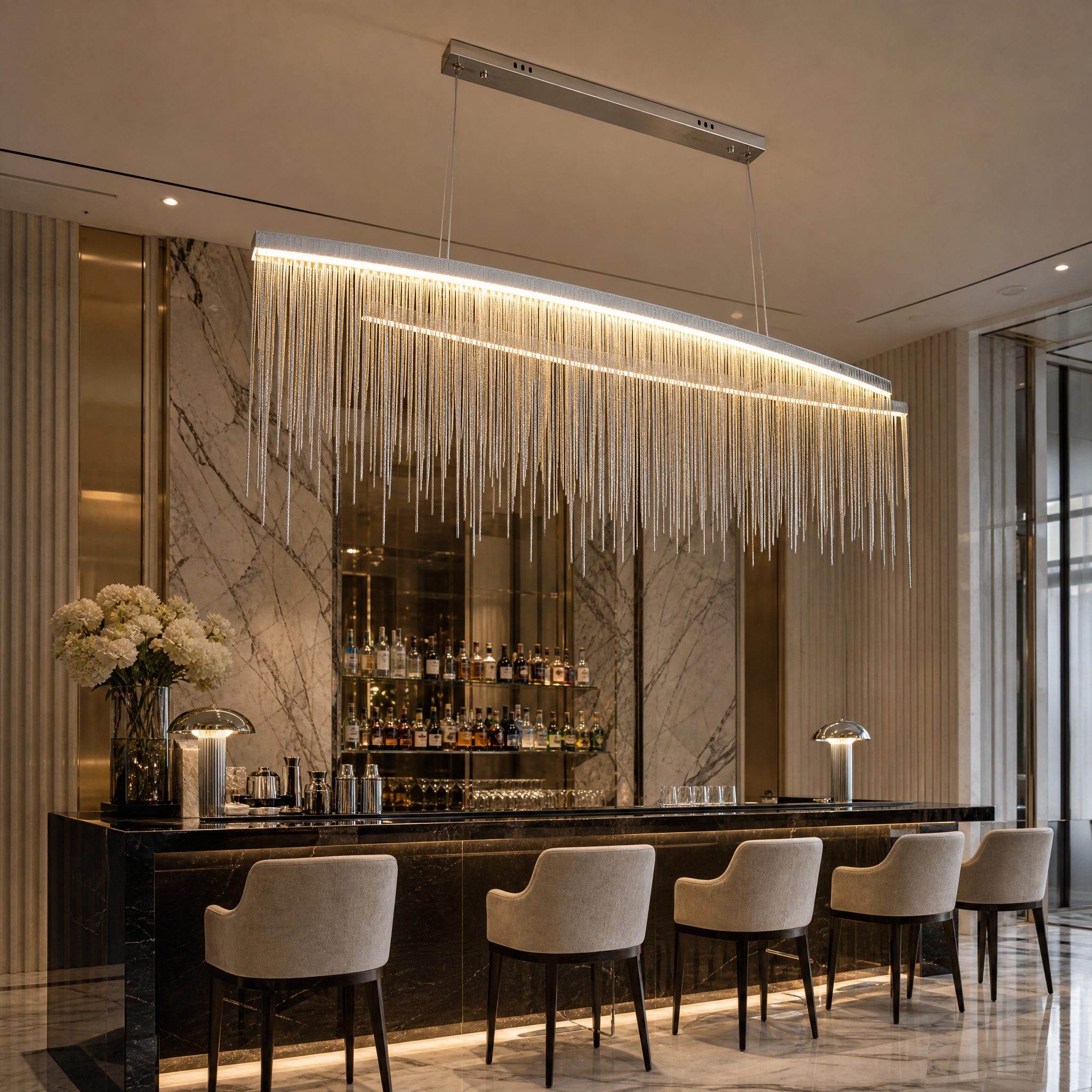 Modern VORELLI Adlington Arc Rectangular Chandelier illuminating a sophisticated hotel lobby and hospitality reception lounge area.
