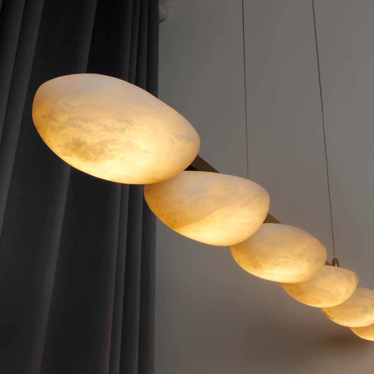 Side view of VORELLI® Alba Rectangular Chandelier featuring smooth marble half-spheres aligned in sequence