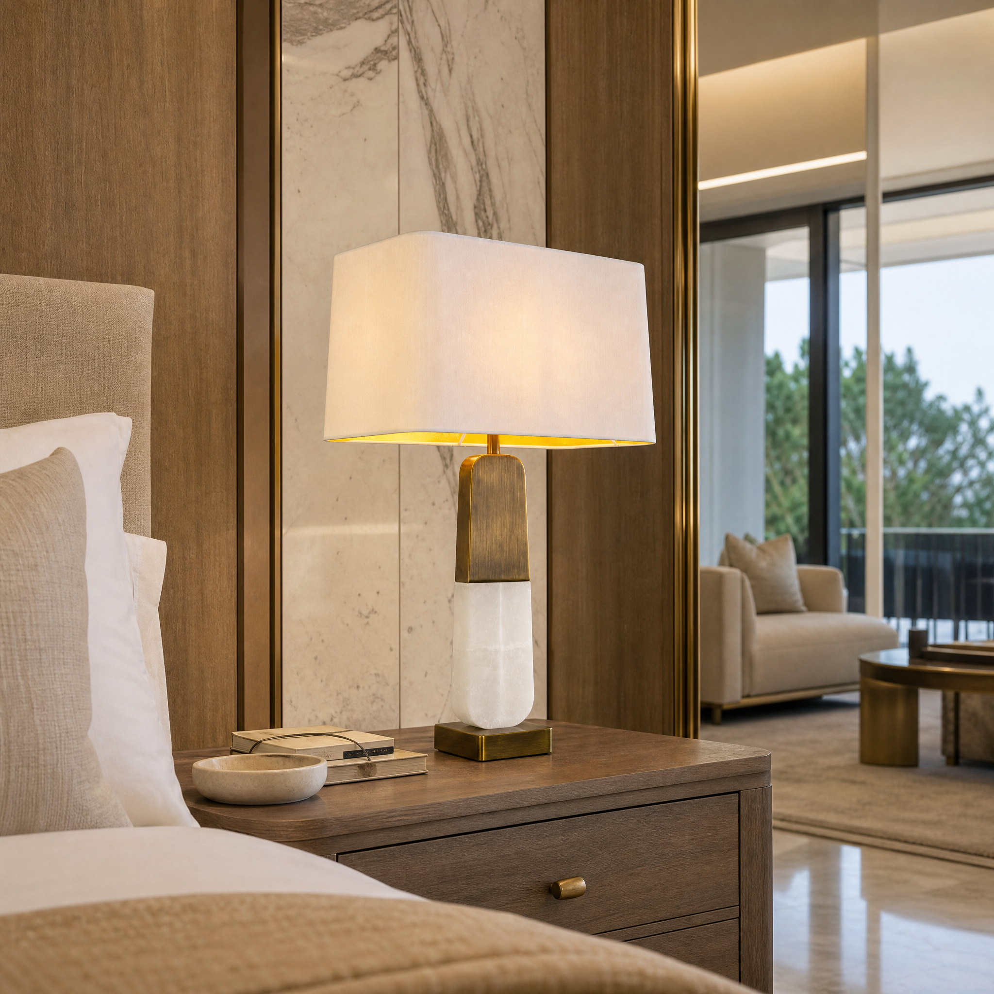 VORELLI Alvani contemporary alabaster table lamp with a soft cream fabric shade illuminating an upscale hotel lobby or executive lounge interior.