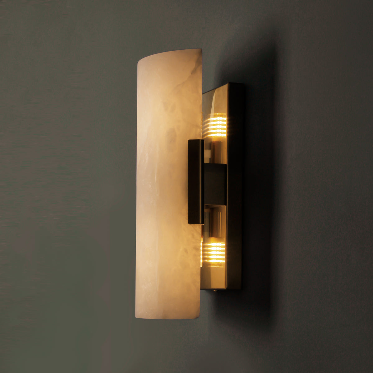 Warm illumination of the curved marble body in a dark interior setting.