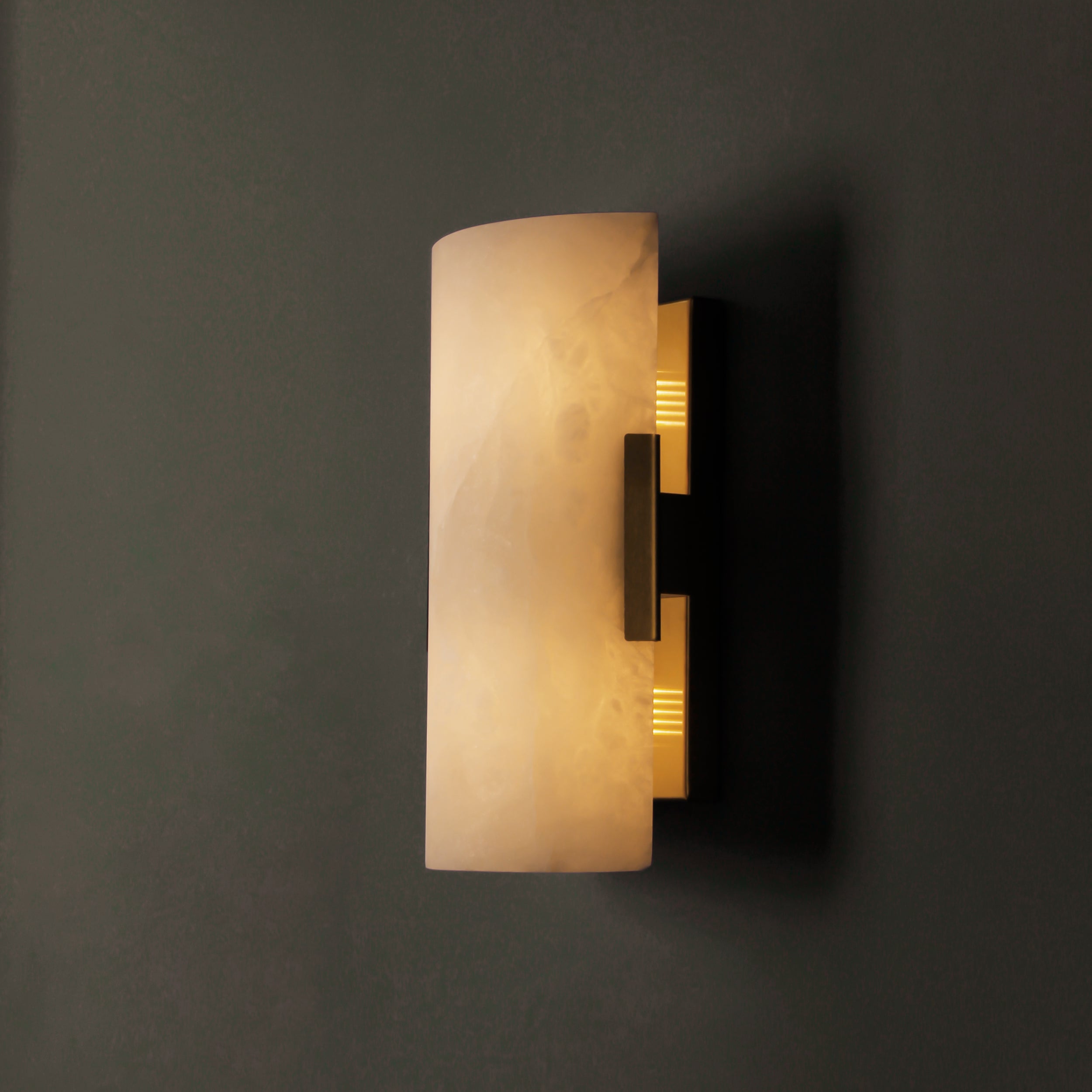 Front view of curved marble wall light with soft ambient glow and sleek detailing.
